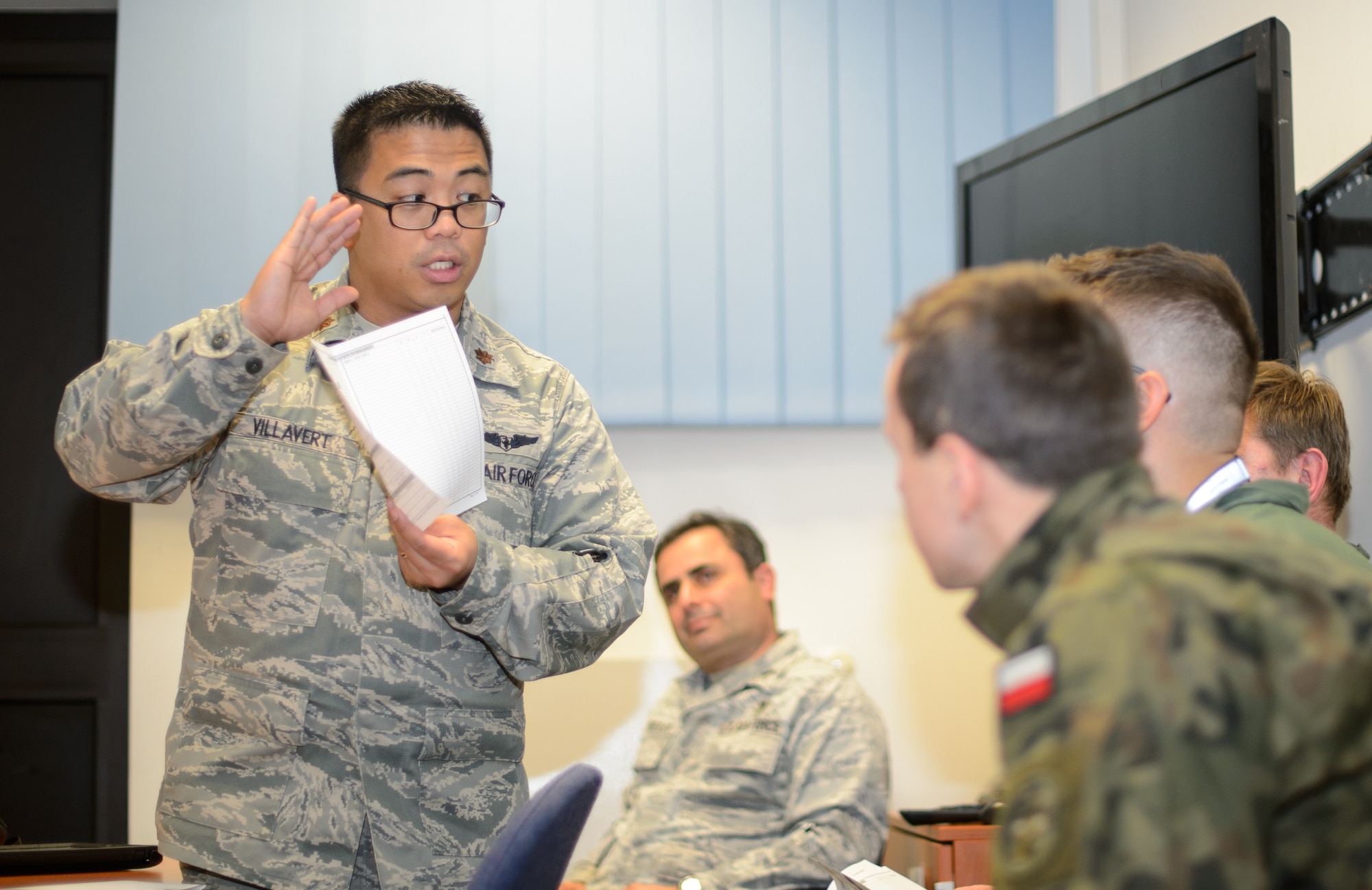 U.S. Air Force Maj. Joel Villavert, 86th Aeromedical Evacuation Squadron flight nurse examiner, goes over an evaluation form with Polish aeromedical evacuation doctors during a familiarization visit Dec. 1, 2015, at Ramstein Air Base, Germany. Airmen from the 86th AES, 10th Expeditionary Aeromedical Evacuation Flight, 603rd Air and Space Operations Center and U.S. Transportation Command’s Theater Patient Movement Requirement Center-East provided an overview of the aeromedical evacuation process. (U.S. Air Force photo/Staff Sgt. Armando A. Schwier-Morales)