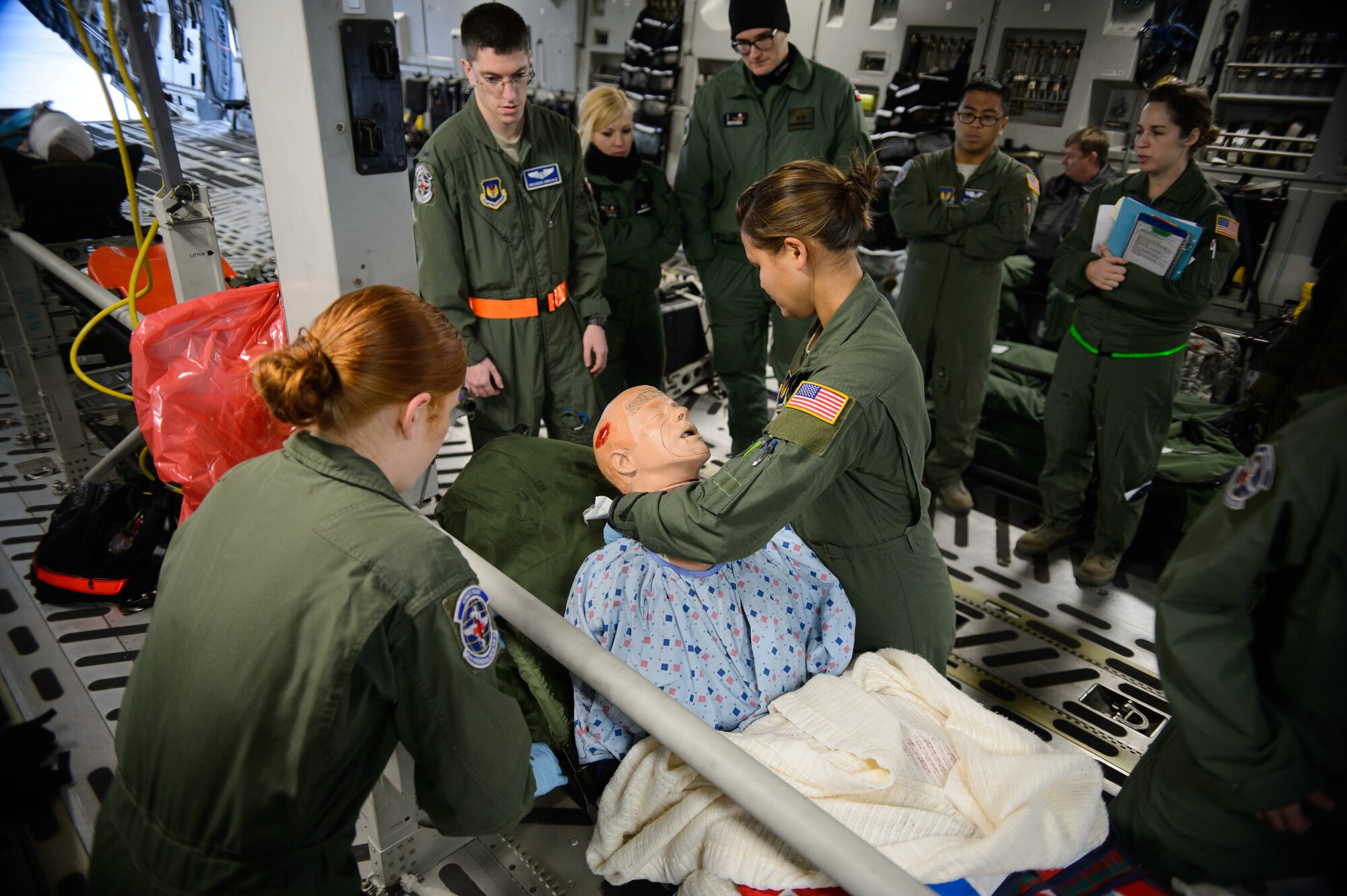 Members of the 86th Aeromedical Evacuation Squadron provide care to a simulated patient as Polish aeromedical evacuation specialists watch Dec. 3, 2015 at Ramstein Air Base, Germany. Three Polish doctors and one paramedic visited Ramstein’s aeromedical facilities to improve their processes. (U.S. Air Force photo/Staff Sgt. Armando A. Schwier-Morales)