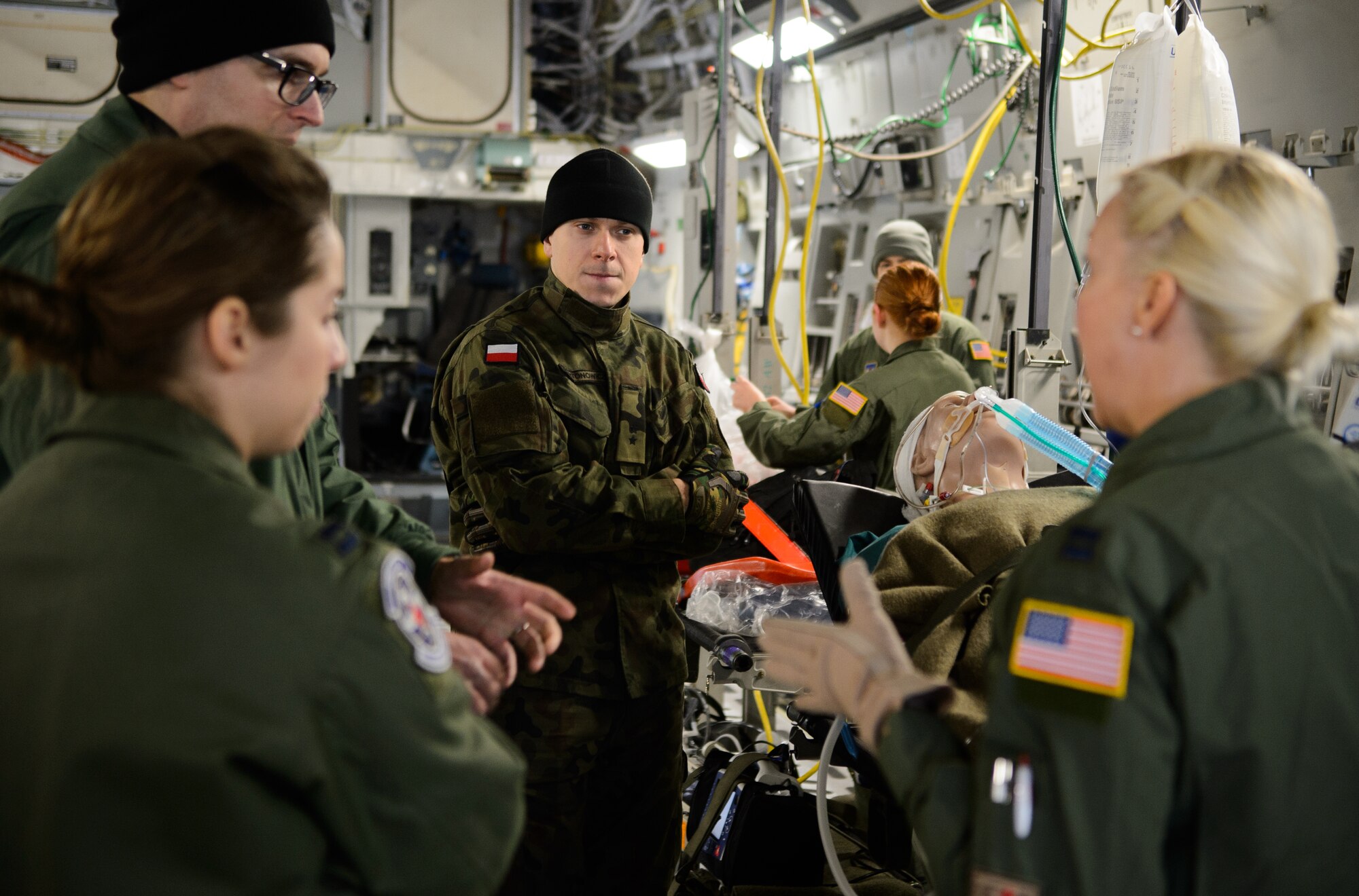Polish air force 2nd Lt. Andrzej Nartonowicz, center, aeromedical evacuation doctor, listens as members of the 86th Aeromedical Evacuation Squadron and Ramstein’s Critical Care Air Transport Team speak with Polish aeromedical evacuation doctors Dec. 3, 2015, at Ramstein Air Base, Germany. Ramstein’s aeromedical evacuation teams showcased their skills and capabilities and shared knowledge with the Polish aeromedical evacuation team touring Ramstein. (U.S. Air Force photo/Staff Sgt. Armando A. Schwier-Morales)