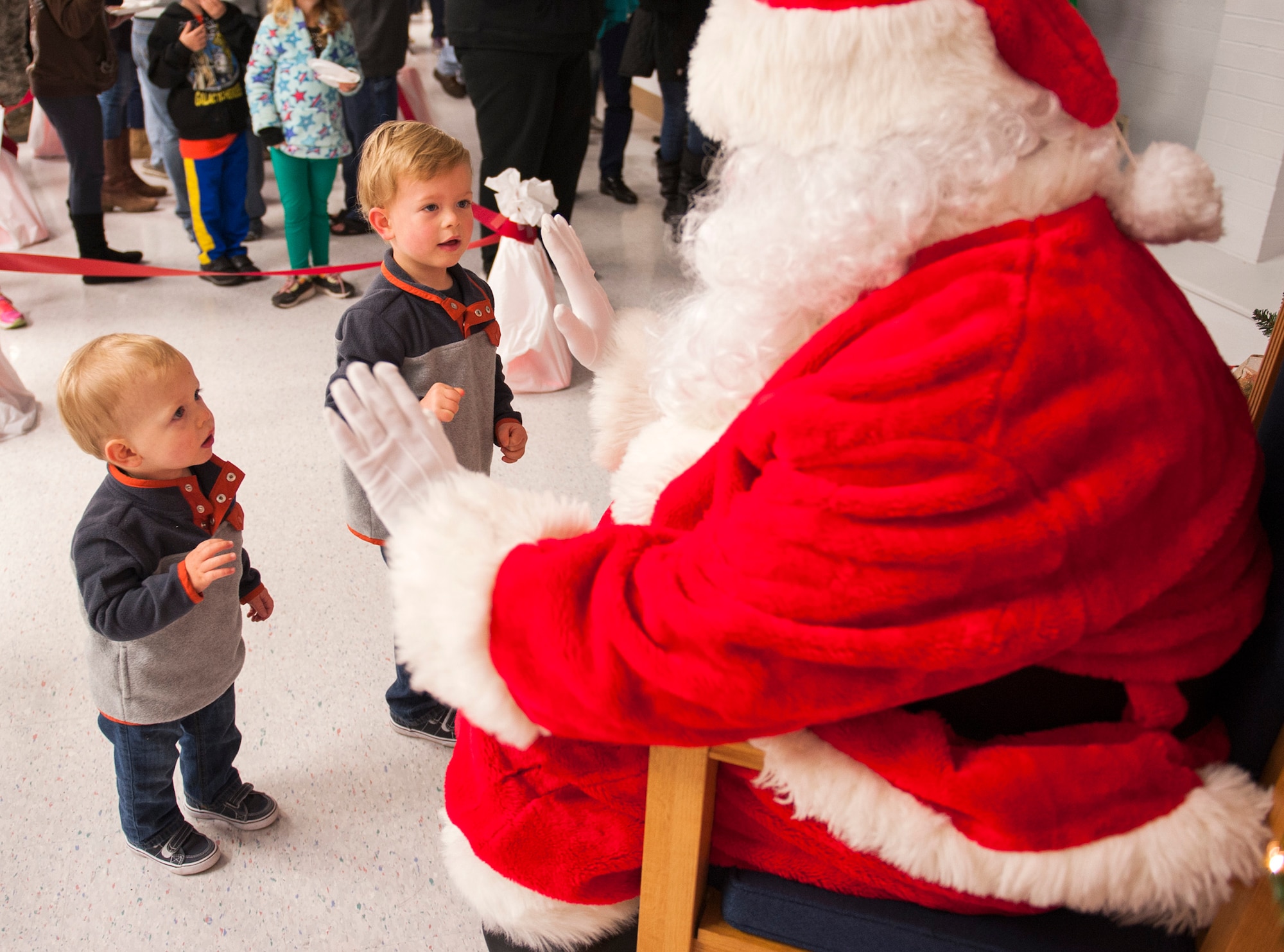 Santa Claus tries for a double high-five from two little boys during the base’s Christmas tree lighting festivities Dec. 4 at Eglin Air Force Base, Fla. The base community came out for the tree lighting, the announcement of the base Christmas card contest winners and the Chapel’s holiday reception. (U.S. Air Force photo/Ilka Cole)