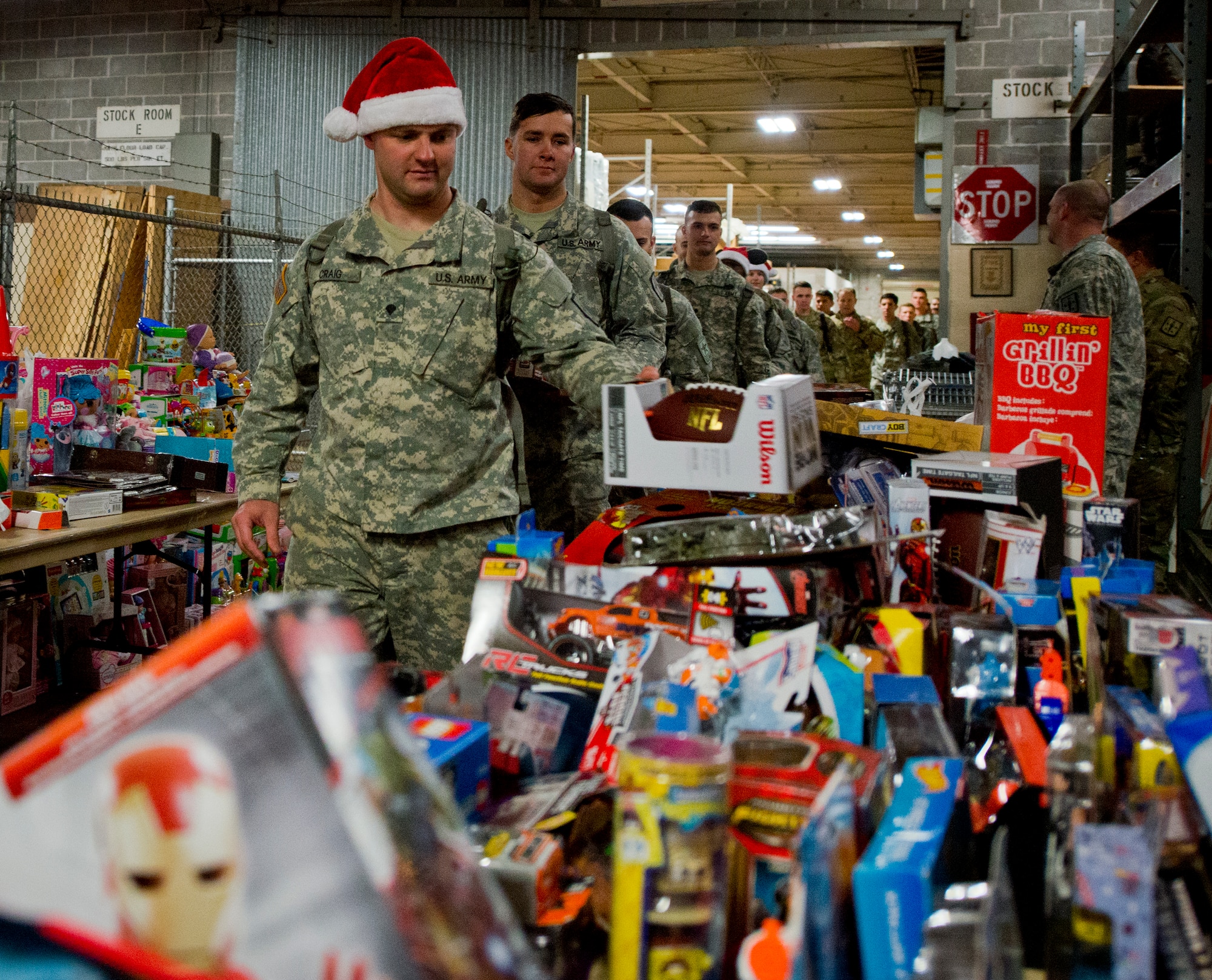 A line of Army explosive ordnance disposal students drop off toys for the base’s annual toy distribution drive Dec. 3 at Bldg. 615 on Eglin Air Force Base, Fla. More than 200 active duty members and their families picked out the toys, books and bikes Dec. 4-5. (U.S. Air Force photo/Samuel King Jr.)