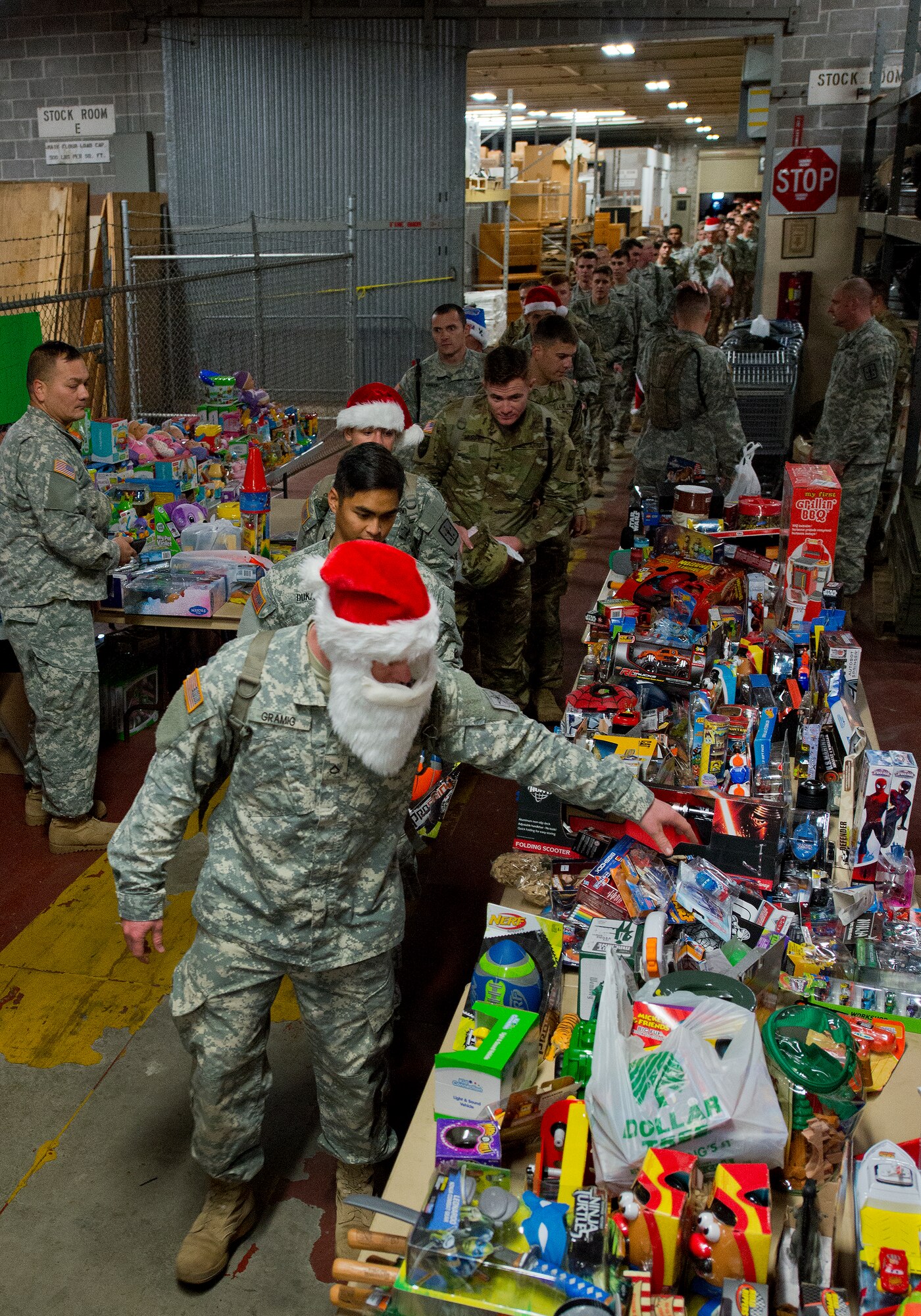 A line of Army explosive ordnance disposal students drop off toys for the base’s annual toy distribution drive Dec. 3 at Bldg. 615 on Eglin Air Force Base, Fla. More than 200 active duty members and their families picked out the toys, books and bikes Dec. 4-5. (U.S. Air Force photo/Samuel King Jr.)