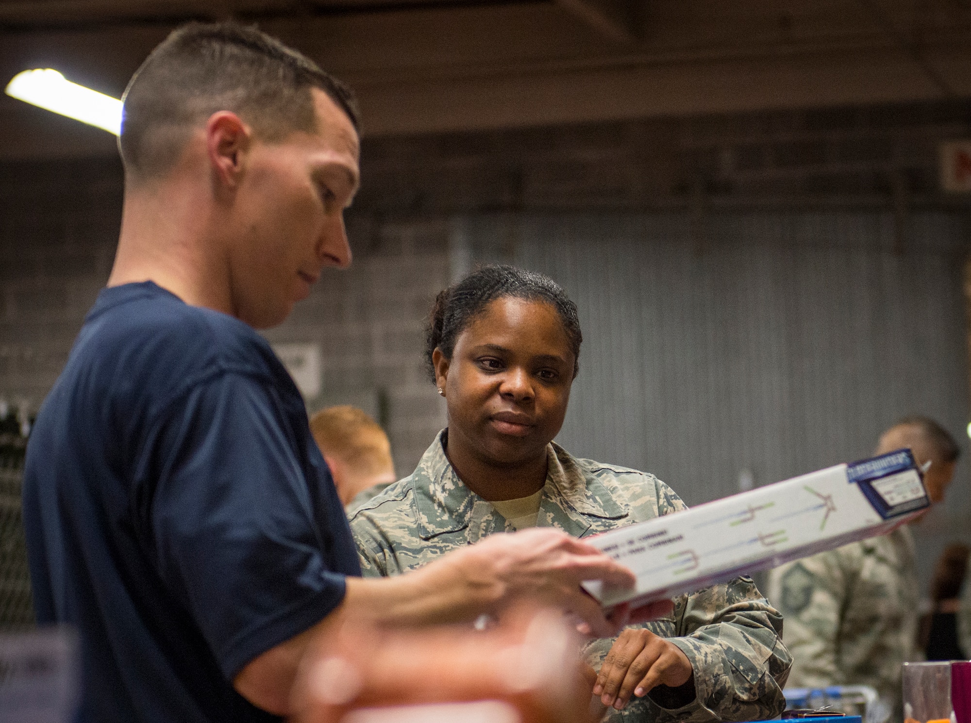 Master Sgt. Justin Klein, the 96th Surgical Operations Squadron first sergeant, helps an Airman make a toy decision during the annual holiday toy distribution at Eglin Air Force Base, Fla., Dec. 4.  Approximately 2,000 toys were collected by donations made throughout the year. Toys, bikes, books, games, crafts, sports equipment and stuffed animals were given to active-military families in need of assistance during the holidays.  (U.S. Air Force photo/Samuel King Jr.)