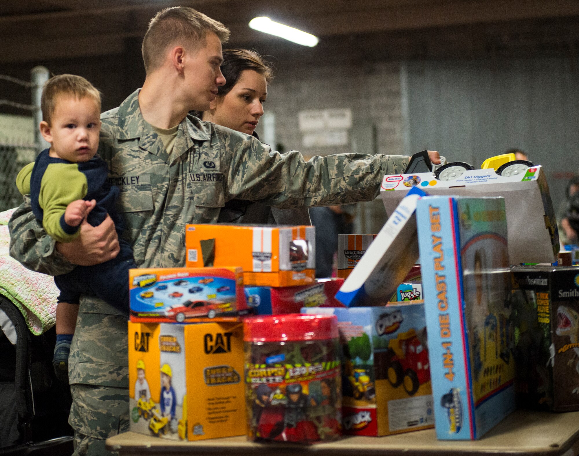 Senior Airman Andrew Heickley, 85th Test and Evaluation Squadron, and his family check out the available items during the annual holiday toy distribution at Eglin Air Force Base, Fla., Dec. 4.  Approximately 2,000 toys were collected by donations made throughout the year. Toys, bikes, books, games, crafts, sports equipment and stuffed animals were given to active-military families in need of assistance during the holidays.  (U.S. Air Force photo/Samuel King Jr.)