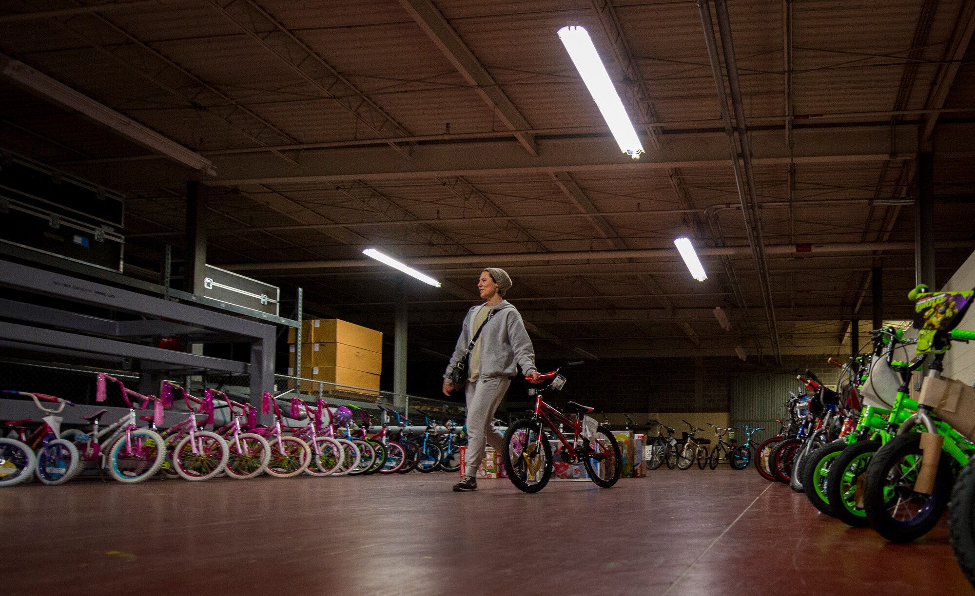 A family member chooses a new bike for her child during the annual holiday toy distribution at Eglin Air Force Base, Fla., Dec. 4.  Approximately 2,000 toys were collected by donations made throughout the year. Toys, bikes, books, games, crafts, sports equipment and stuffed animals were given to active-military families in need of assistance during the holidays.  (U.S. Air Force photo/Samuel King Jr.)