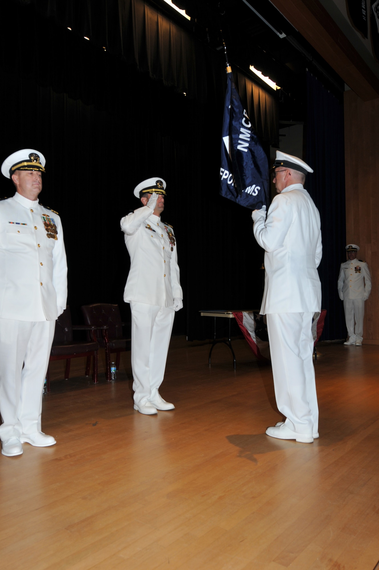 CMDCM James McKinney, Naval Mobile Construction Battalion 14 command master chief, right, begins the transfer of the command colors from Cmdr. Marc F. Williams (center) to Cmdr. David Wilhite. This display is symbolic of the peaceful transfer of command from one commanding officer to the next. (U.S. Navy photo/Senior Chief Mass Communication Specialist Jeffrey J. Pierce)