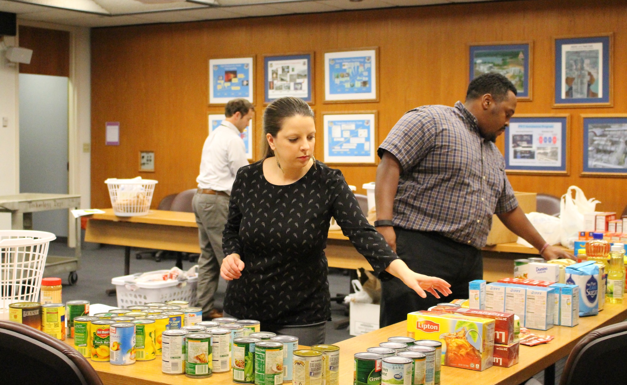 Arnold Junior Force Council members prepare food items at AEDC Nov. 18, 2015, for the Thanksgiving Food Basket Program, which is part of the Coffee County Backpack Program. The JFC delivered 22 food baskets which included food donations from AEDC team members. Pictured left to right is JFC President Will Mallory, and JFC members Andrea McElroy and Artious Walker. (U.S. Air Force photo/Holly Fowler)