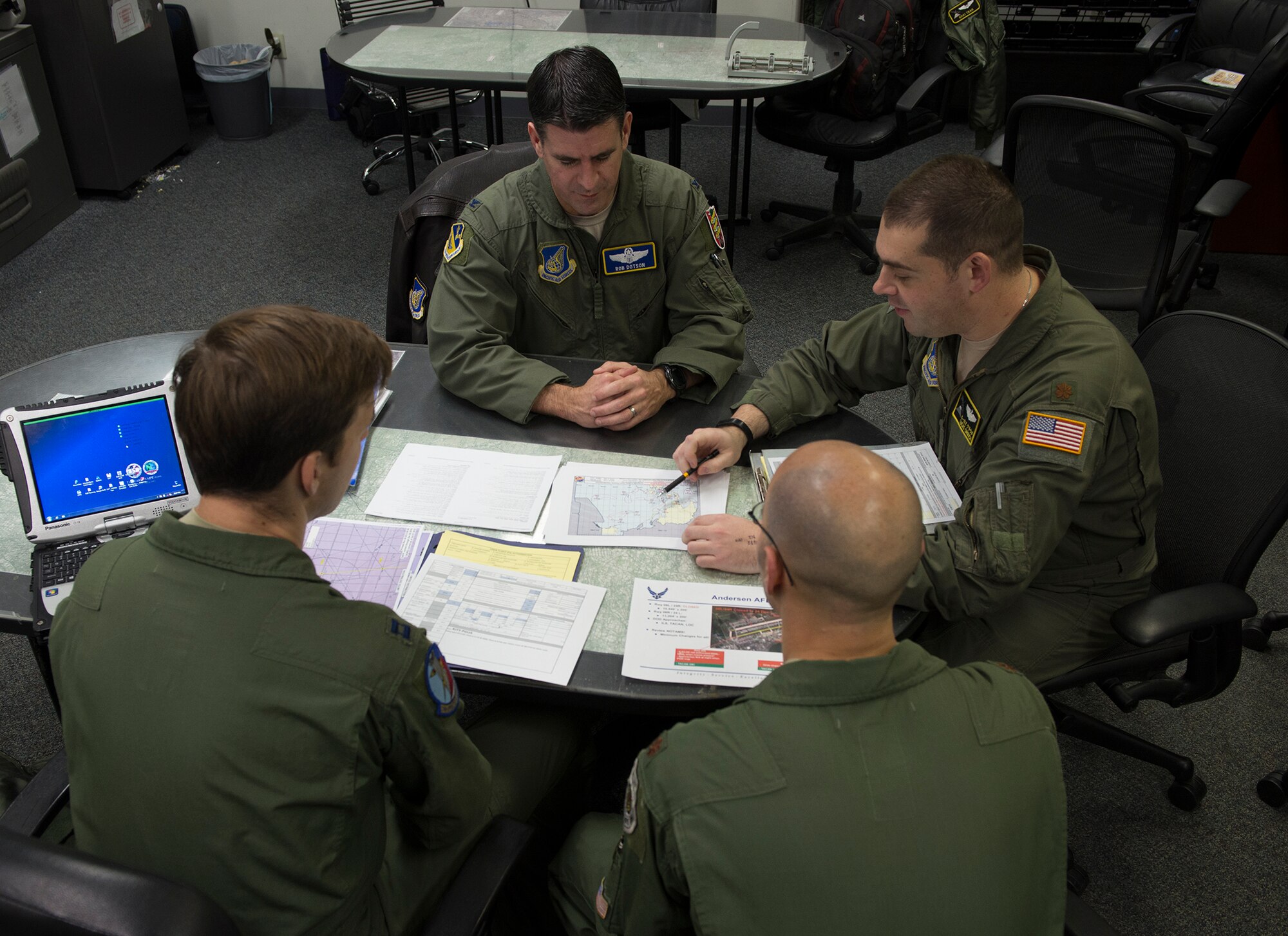 Airmen check planned routes and weather conditions during a pre-flight briefing for Operation Christmas Drop 2015 at Yokota Air Base, Japan, Dec. 7, 2015. Over the course of six days, critical supplies will be dropped to 56 Micronesian islands, impacting approximately 20,000 people as part of the longest-running Department of Defense humanitarian aid disaster relief mission. (U.S. Air Force photo by Senior Airman David C. Danford/Released)