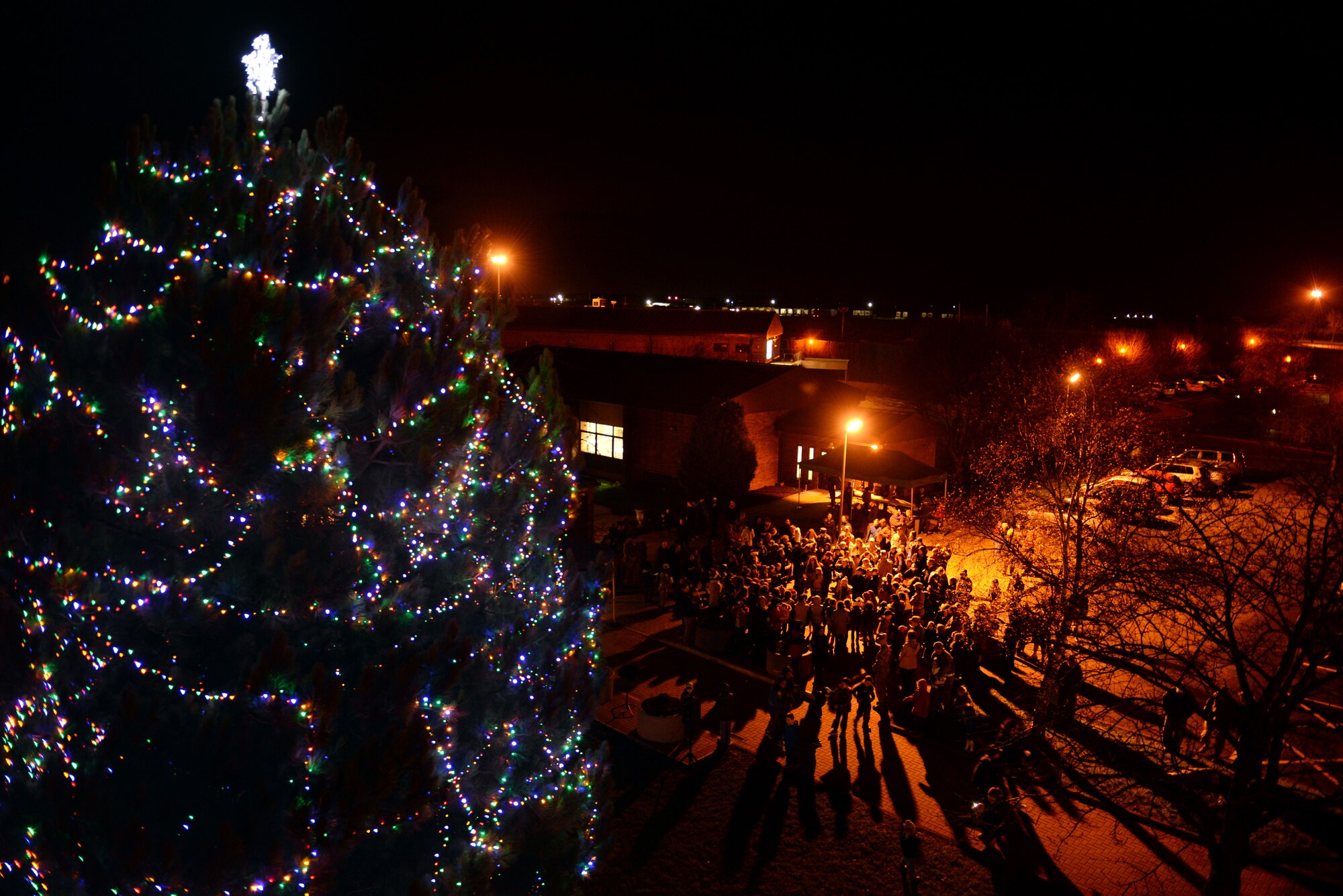 Service members and their families gather during a Christmas tree lighting ceremony, Dec. 3, 2015, on RAF Alconbury, United Kingdom. The 501st Combat Support Wing leadership team stresses that Airmen should enjoy the holiday season, but also remain safe and stay vigilant. (U.S. Air Force photo be Airman 1st Class Zachary Bumpus/Released)