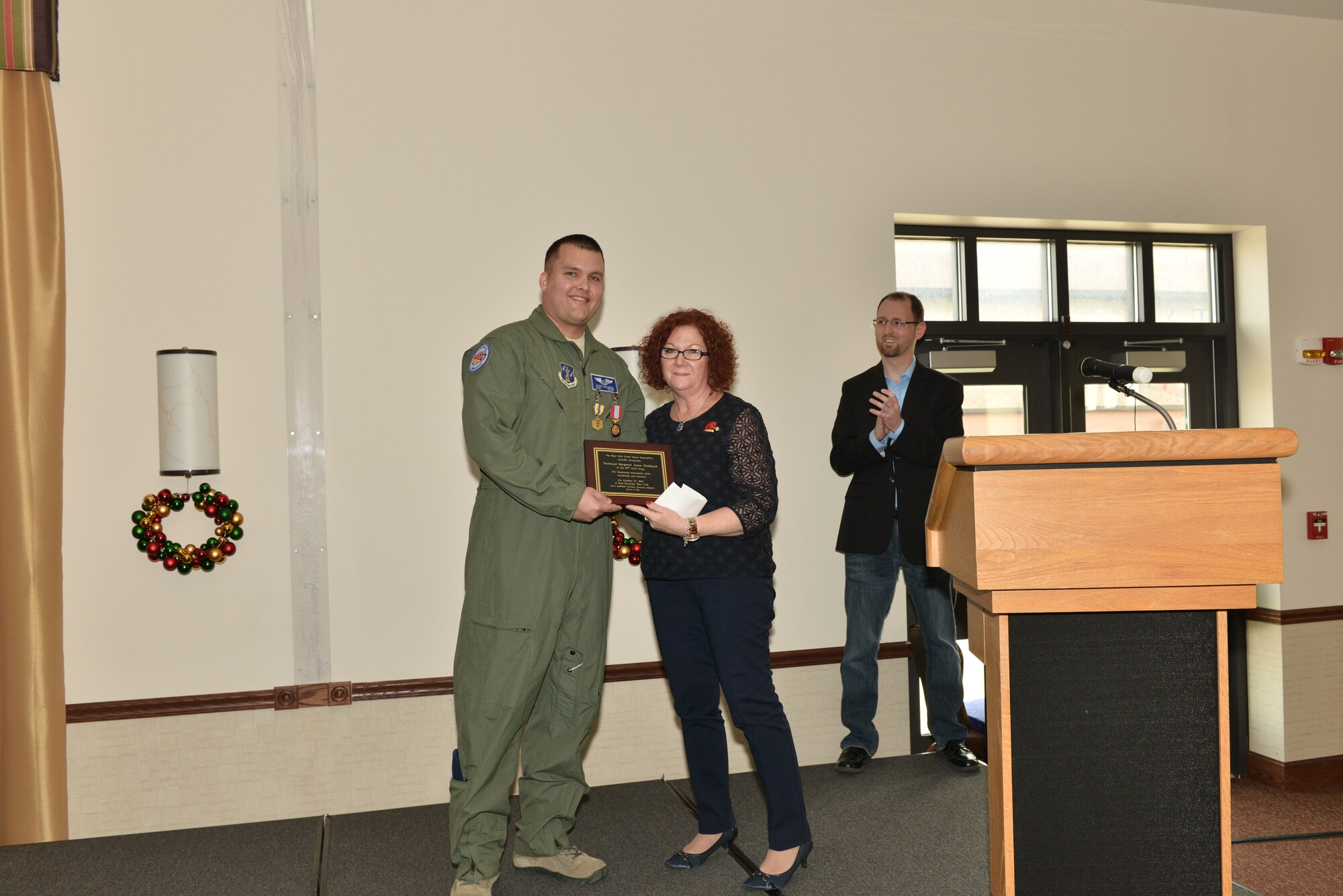 Tech. Sgt. Jason Oehlbeck receives an award from Marie Betti Dec. 6, 2015. The New York Credit Union Association recognized Oehlbeck for displaying remarkable skills, leadership and heroism when he saved the life of one of their colleagues by performing CPR. (U.S. Air National Guard Photo/Senior Master Sgt. Ray Lloyd)