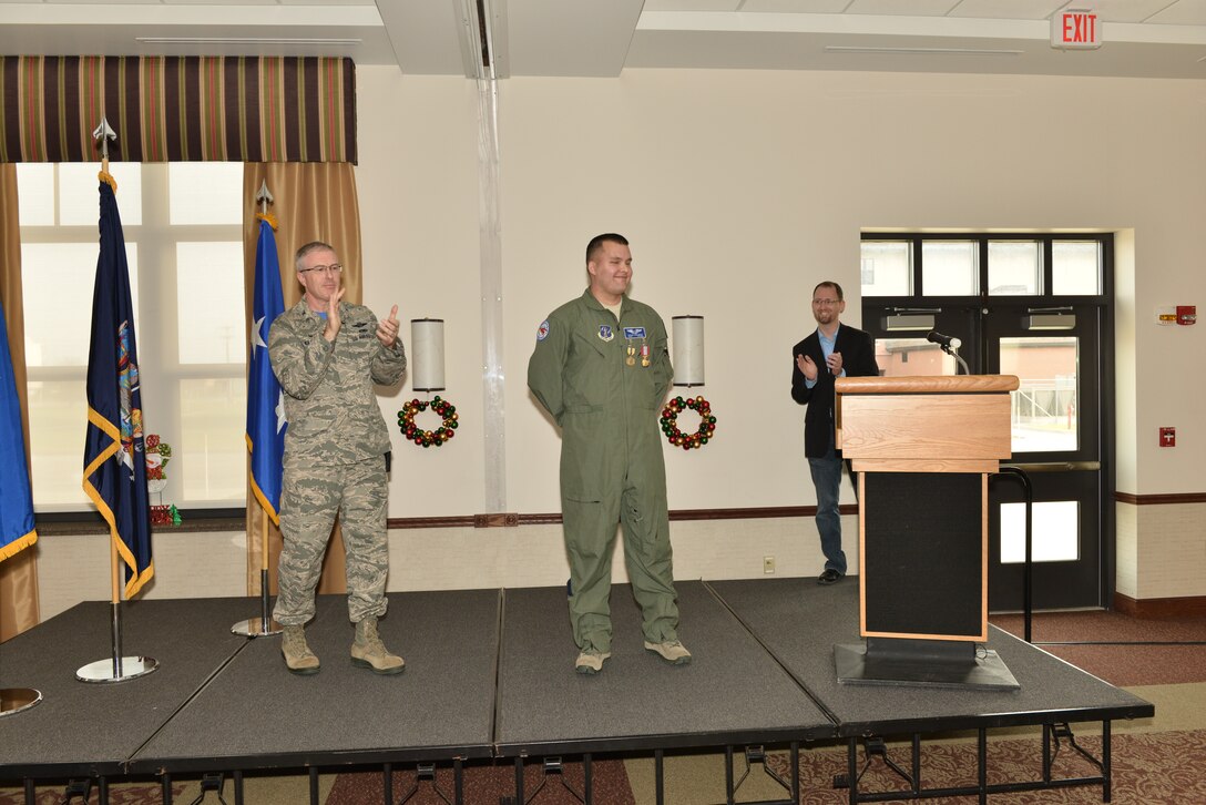 Tech. Sgt. Jason N. Oehlbeck, a member of the 107th Airlift Wing, was awarded the Air Force Commendation Medal and the New York State Medal for Meritorious Service. Col. Robert Kilgore applauds Oehlbeck for saving Jack Ewald’s life at a ceremony Dec. 6, 2015. (U.S. Air National Guard Photo/Senior Master Sgt. Ray Lloyd)