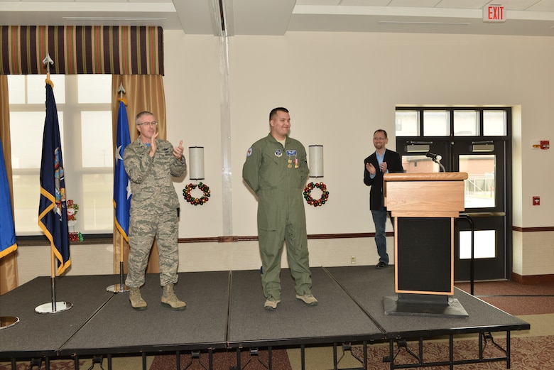 Tech. Sgt. Jason N. Oehlbeck, a member of the 107th Airlift Wing, was awarded the Air Force Commendation Medal and the New York State Medal for Meritorious Service. Col. Robert Kilgore applauds Oehlbeck for saving Jack Ewald’s life at a ceremony Dec. 6, 2015. (U.S. Air National Guard Photo/Senior Master Sgt. Ray Lloyd)