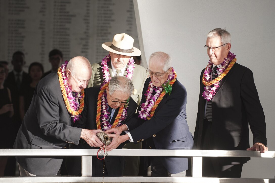American and Japanese veterans pour bourbon whiskey into the waters of Pearl Harbor as a way to observe and celebrate the continued peace and reconciliation between the two nations during a Blackened Canteen ceremony as part of the Pearl Harbor Day Commemoration Anniversary at the USS Arizona Memorial, Hawaii, Dec. 6, 2015. U.S. Air Force photo by Staff Sgt. Christopher Hubenthal