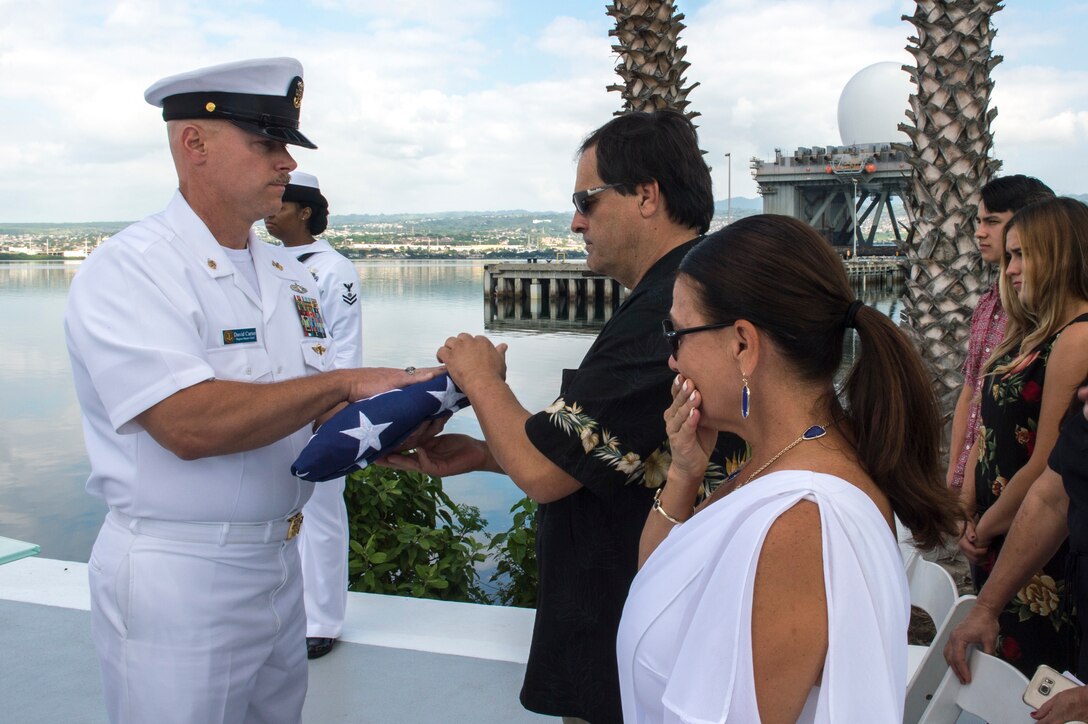 Children of retired Navy Chief boatswain's mate Donald Show, a USS Phoenix survivor, accept flags as part of an ash-scattering ceremony at the USS Utah Memorial during the Pearl Harbor Day commemoration anniversary at Joint Base Pearl Harbor-Hickam, Hawaii, Dec. 7, 2015. U.S. Navy photo by Petty Officer 3rd Class Katarzyna Kobiljak