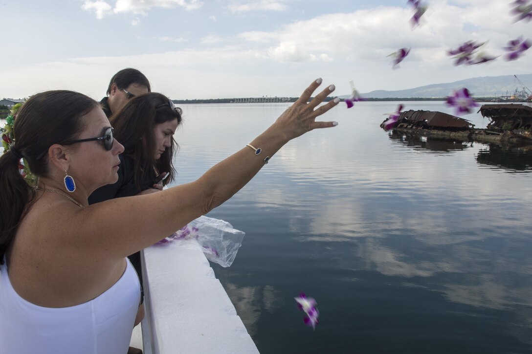 Jeannette Siciliani, daughter of retired Navy Chief boatswain's mate Donald Show, a USS Phoenix survivor, throws flowers during an ash-scattering ceremony at the USS Utah Memorial during the Pearl Harbor Day commemoration anniversary at Joint Base Pearl Harbor-Hickam, Hawaii, Dec. 7, 2015. U.S. Navy photo by Petty Officer 3rd Class Katarzyna Kobiljak