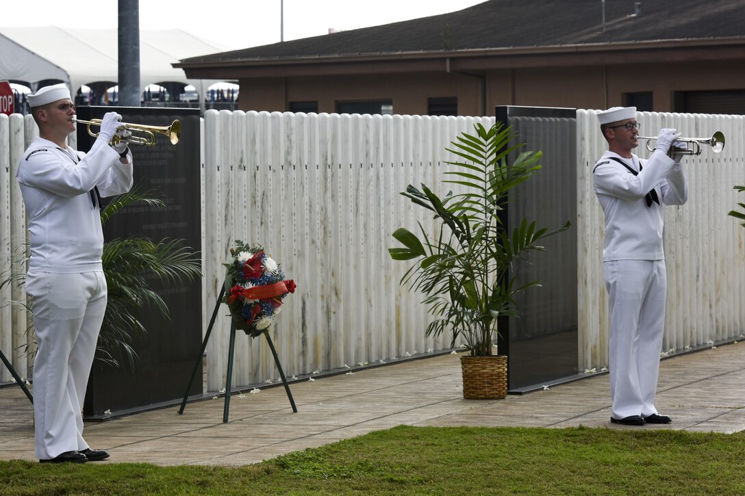 Sailors from the U.S. Pacific Fleet Band play taps at the USS Oklahoma Memorial Remembrance Ceremony honoring service members killed aboard the battleship Oklahoma Dec. 7, 1941, at Joint Base Pearl Harbor-Hickam, Hawaii, Dec. 7, 2015. U.S. Navy photo by Petty Officer 1st Class Rebecca Wolfbrandt