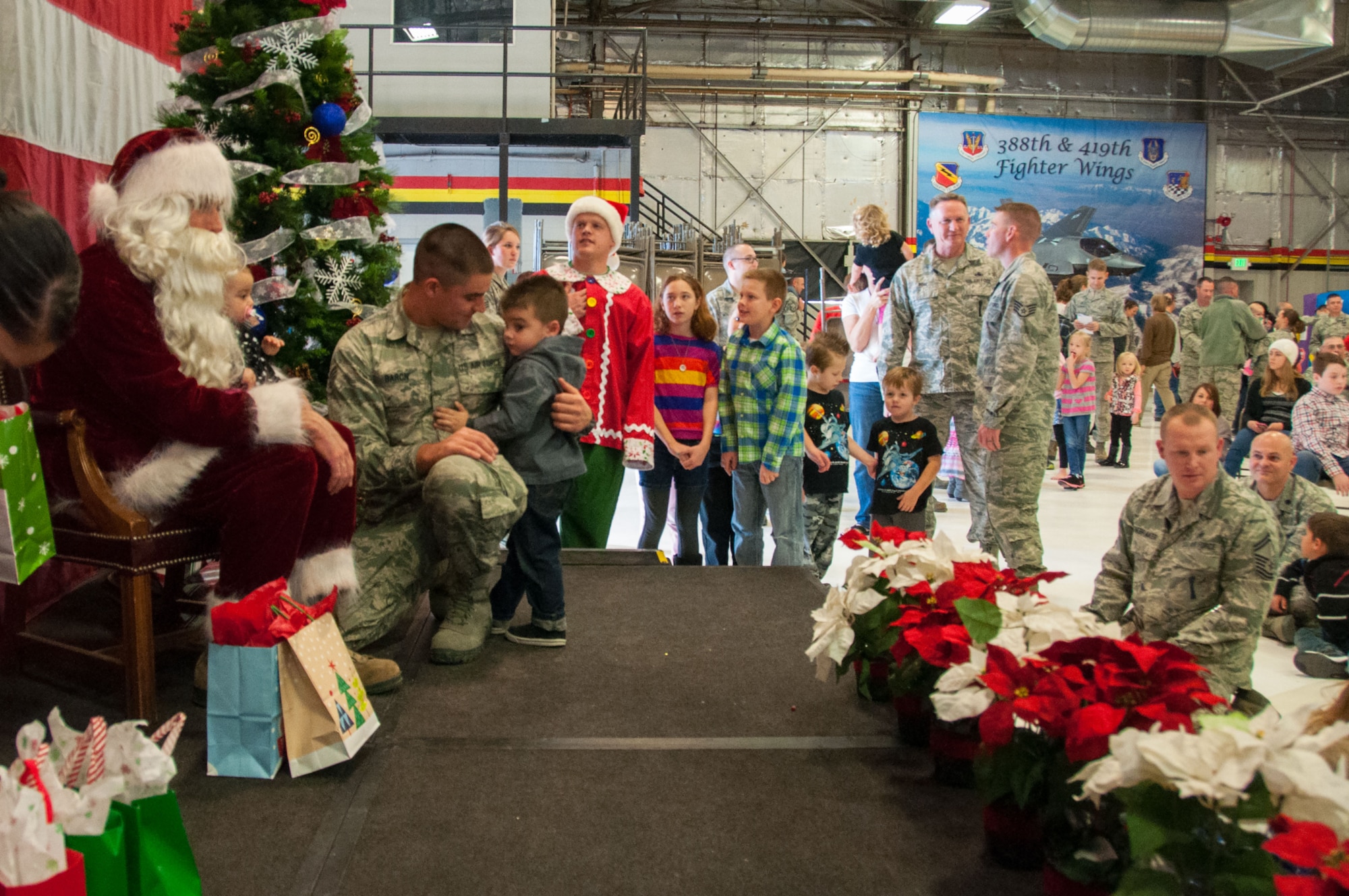 Children of 419th Fighter Wing Reservists line up to meet Santa Claus at a holiday party here today. About 300 kids were in attendance. Claus jetted in from the North Pole in an F-16 to pass out early Christmas gifts.