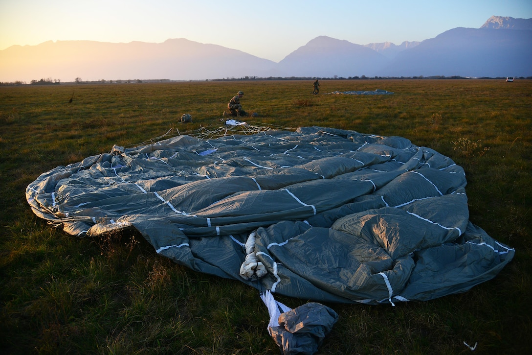 A U.S. paratrooper recovers his parachute after an airborne operation from a U.S. Air Force C-130 Hercules aircraft at Juliet drop zone in Pordenone, Italy, Dec. 2, 2015. U.S. Army photo by Paolo Bovo