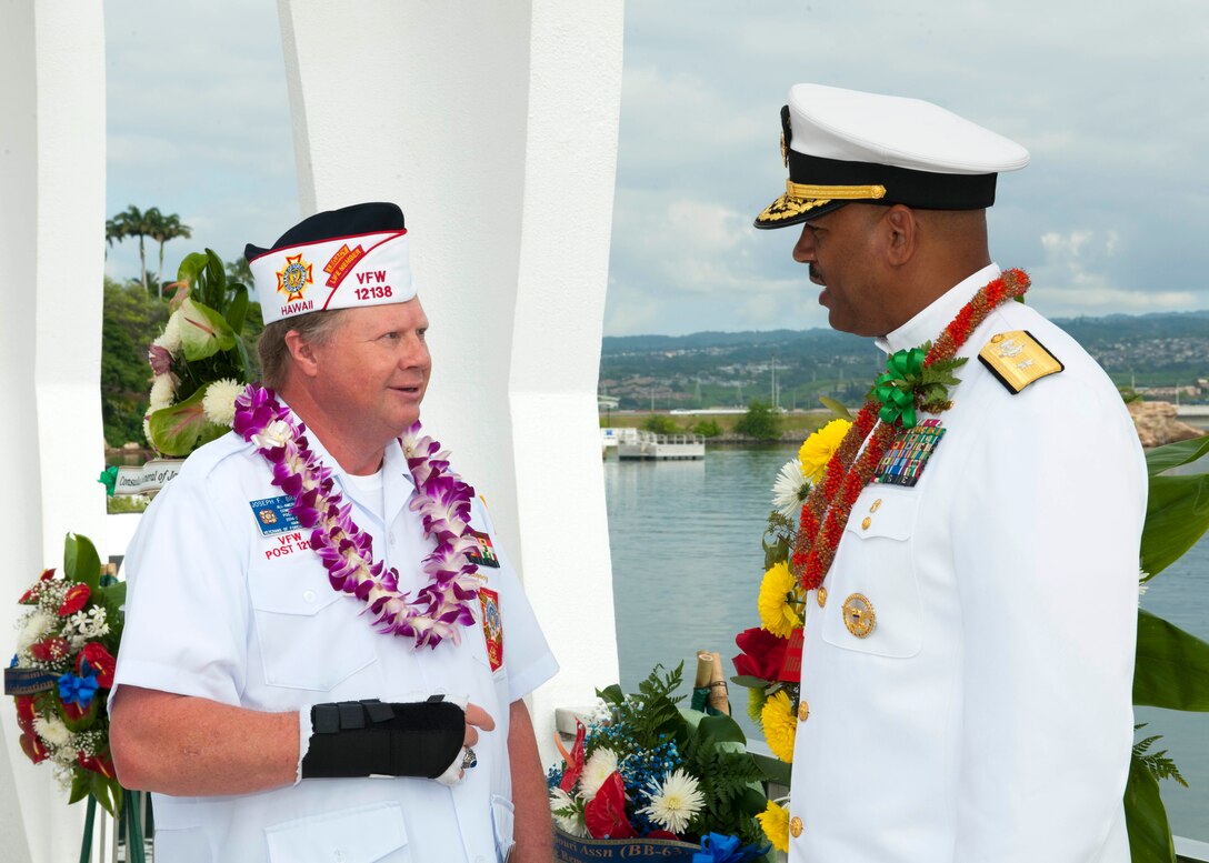 Veteran of Foreign Wars member Joseph Bragg, left, speaks with Navy Rear Adm. John Fuller, commander, Navy Region Hawaii and Naval Surface Group Middle Pacific, during a wreath dedication ceremony in remembrance of the Pearl Harbor attack, on Joint Base Pearl Harbor-Hickam, Hawaii, Dec. 7, 2015. U.S. Navy photo by Petty Officer 2nd Class Jeff Troutman