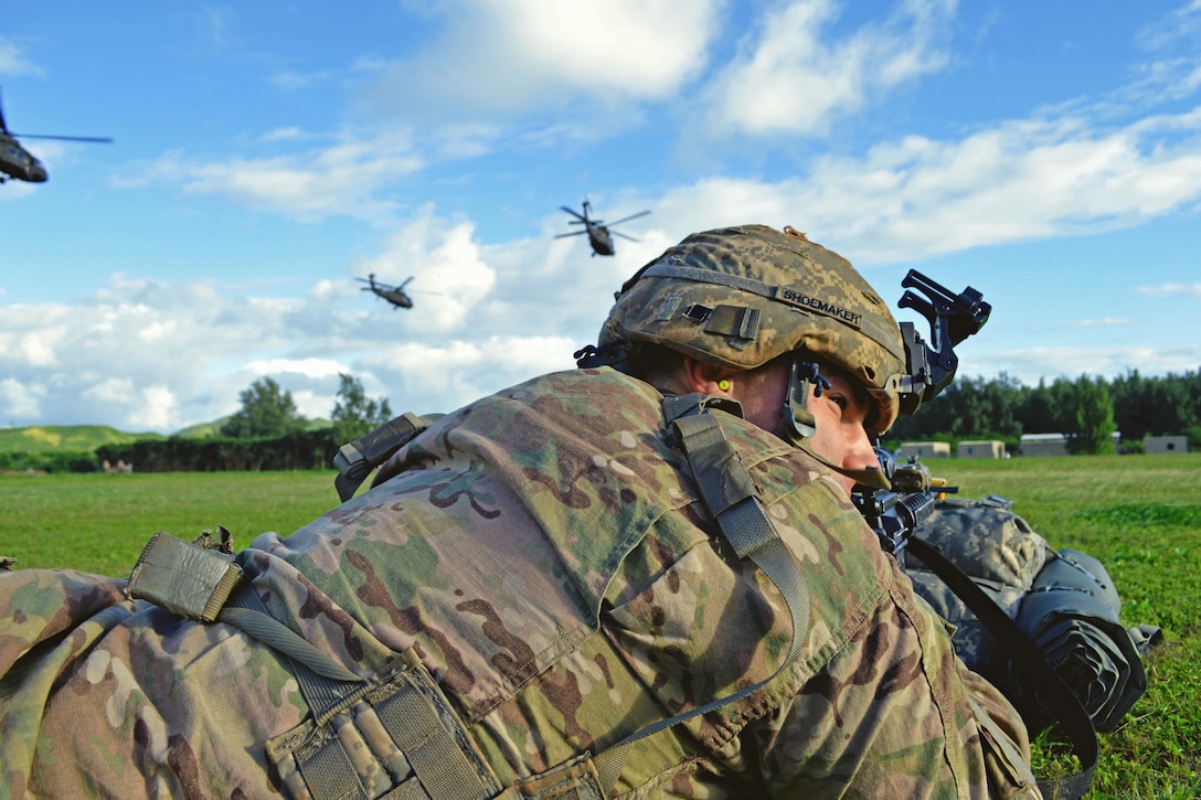 A soldier provides protection as UH-60 Black Hawk helicopters fly from a landing zone on Marine Corps Training Area Bellows, Hawaii, Dec. 2, 2015. The soldier is assigned to 25th Infantry Division’s 2nd Battalion, 35th Infantry Regiment, 3rd Brigade Combat Team. U.S. Army photo by Staff Sgt. Armando R. Limon