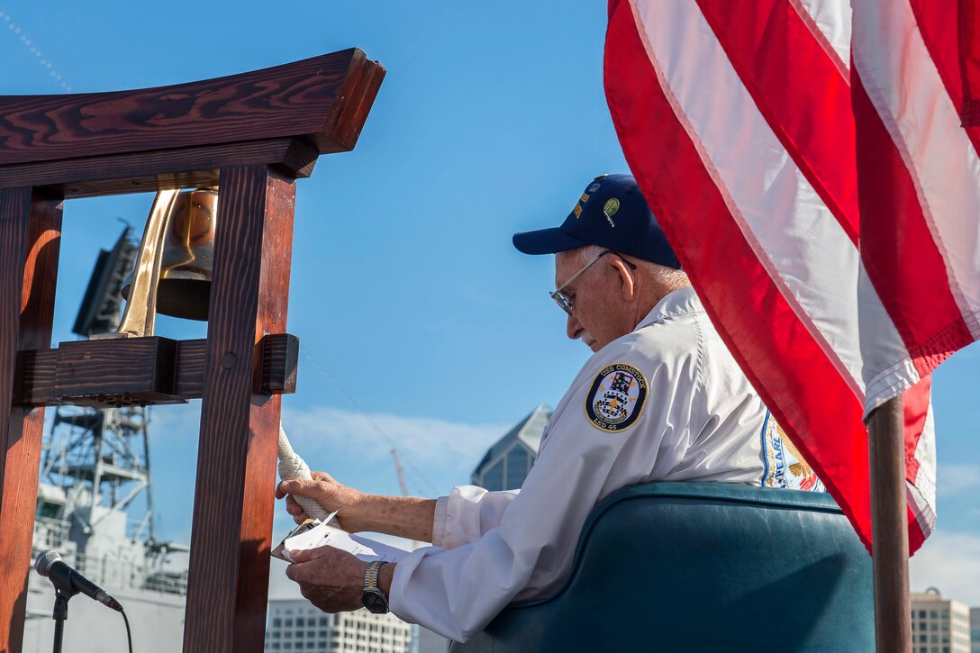 Ben Valeu, a Pearl Harbor survivor, rings a bell during a Pearl Harbor Remembrance ceremony aboard the USS Midway Museum in San Diego, California, Dec. 7, 2015. The bell is rung for the Two-Bell ceremony that honors Pearl Harbor survivors who have passed away this year. U.S. Navy photo by Petty Officer 3rd Class Gerald Dudley Reynolds