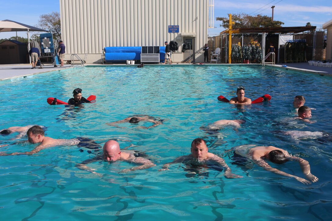 Marines and Sailors train to float above water at the Aviation Water Survival Training Center aboard Marine Corps Air Station Miramar, Calif., Dec. 3. Aviation Water Survival Training is hosted every week, twice a week, and is mandatory for all pilots every four years. (U.S. Marine Corps Photo by Lance Cpl. Harley Robinson/Released)