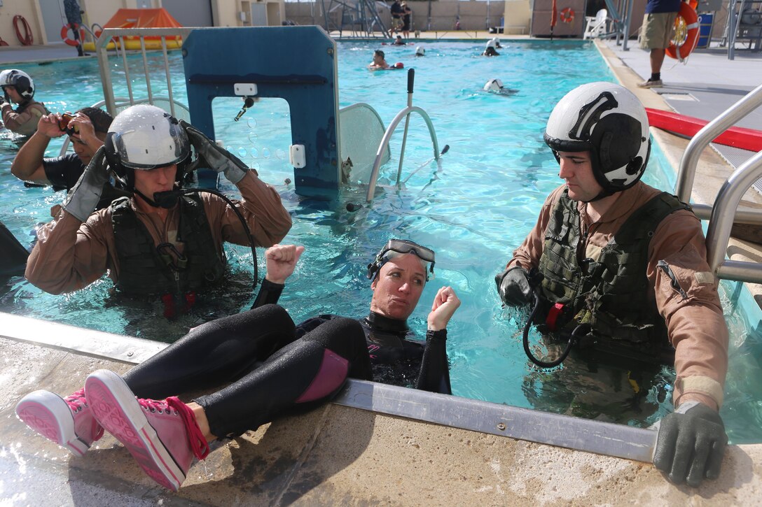 An Aviation Water Survival Training Instructor shows the students how to use their equipment at the Aviation Water Survival Training Center aboard Marine Corps Air Station Miramar, Calif., Dec. 3. Aviation Water Survival Training is hosted every week, twice a week, and is mandatory for all pilots every four years. (U.S. Marine Corps Photo by Lance Cpl. Harley Robinson/Released)