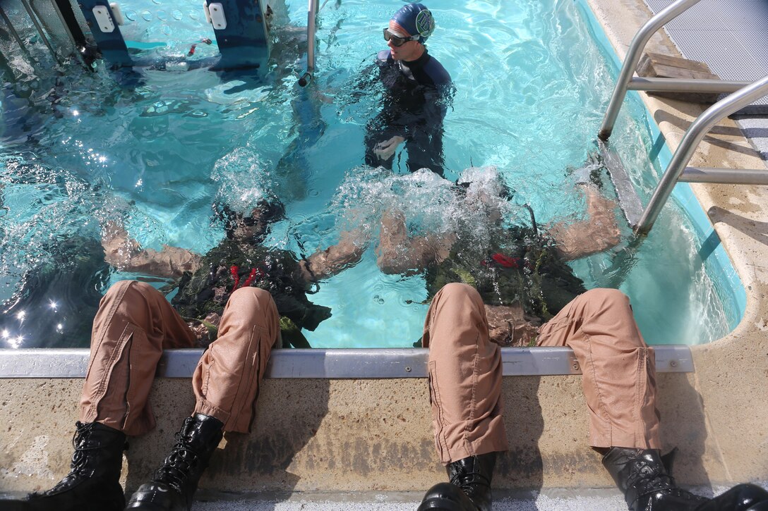 Students at the Aviation Water Survival Training Center train to use their equipment while upside-down underwater aboard Marine Corps Air Station Miramar, Calif., Dec. 3. Aviation Water Survival Training is hosted every week, twice a week, and is mandatory for all pilots every four years. (U.S. Marine Corps Photo by Lance Cpl. Harley Robinson/Released)
