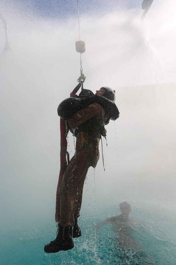 A student is lifted on a helicopter hoist simulator at the Aviation Water Survival Training Center aboard Marine Corps Air Station Miramar, Calif., Dec. 3. Aviation Water Survival Training is hosted every week, twice a week, and is mandatory for all pilots every four years. (U.S. Marine Corps Photo by Lance Cpl. Harley Robinson/Released)