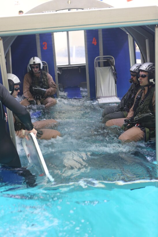 Students are lowered into the pool in the helicopter dunker aboard Aviation Water Survival Training Center aboard Marine Corps Air Station Miramar, Calif., Dec. 3. Aviation Water Survival Training is hosted every week, twice a week, and is mandatory for all pilots every four years. (U.S. Marine Corps Photo by Lance Cpl. Harley Robinson/Released)