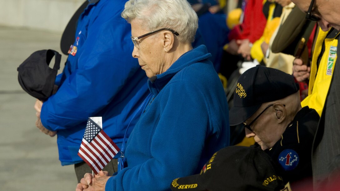Esther Spring, who served in the Army Nurse Corps, and other World War II veterans bow their heads at the start of a Pearl Harbor remembrance ceremony at the National WWII Memorial on Dec. 7, 2015, in Washington, D.C. The attacks on the island of Oahu eventually left more than 2,400 dead and almost 1,200 wounded as it catapulted the U.S. into the war.