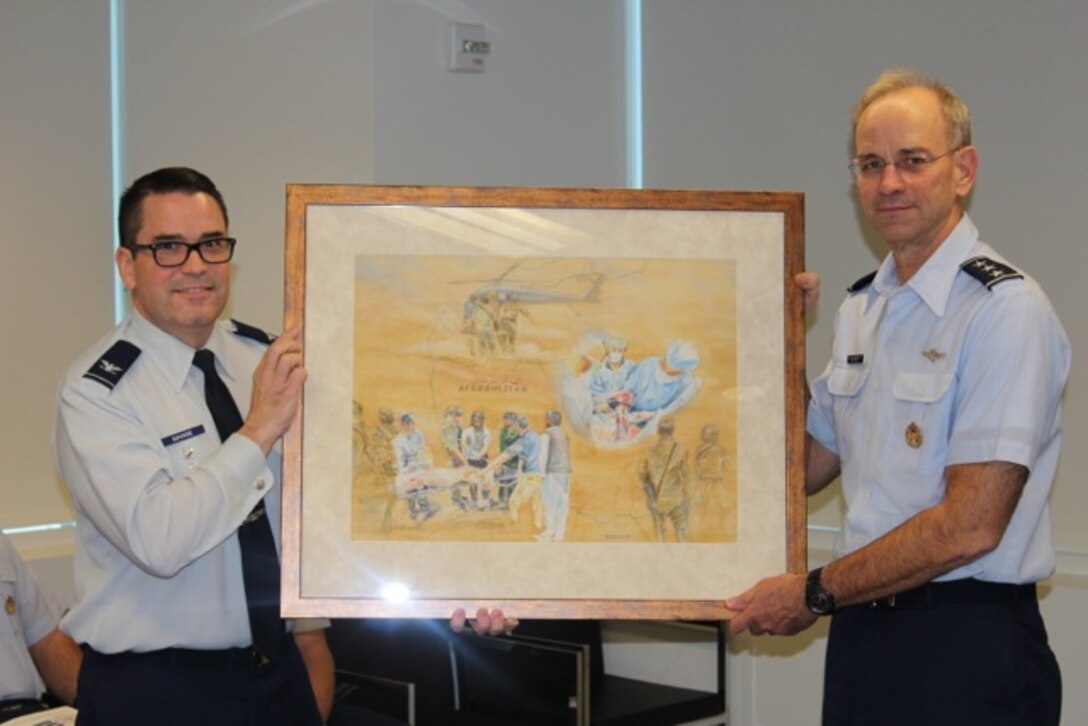 Col. John Savage and Lt. Gen. Mark Ediger display Ms. Judy Blomquist’s painting which depicts AFMS medics in Afghanistan rendering aid after a bombing. The painting was presentedat a ceremony at the DHHQ in Falls Church, Va., on Nov. 27..
Credit: U.S. Air Force by Mr. Tony Joyner
