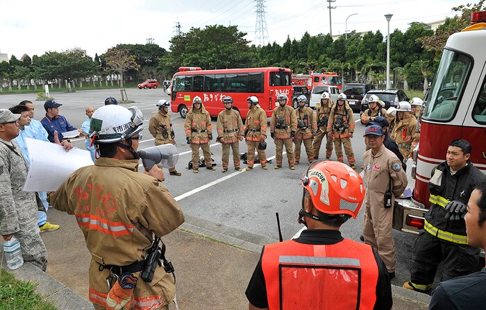 Yasuaki Nakama, Okinawa City Fire Department captain, briefs a training plan to Okinawa City Fire Department and Kadena Fire Department crew members during a bilateral hazardous materials training exercise, Dec. 8, 2015, at the Okinawa City Civic Center, Japan. The Kadena Fire Department and Okinawa City Fire Department trained together to build proficiency and understanding with each other. 