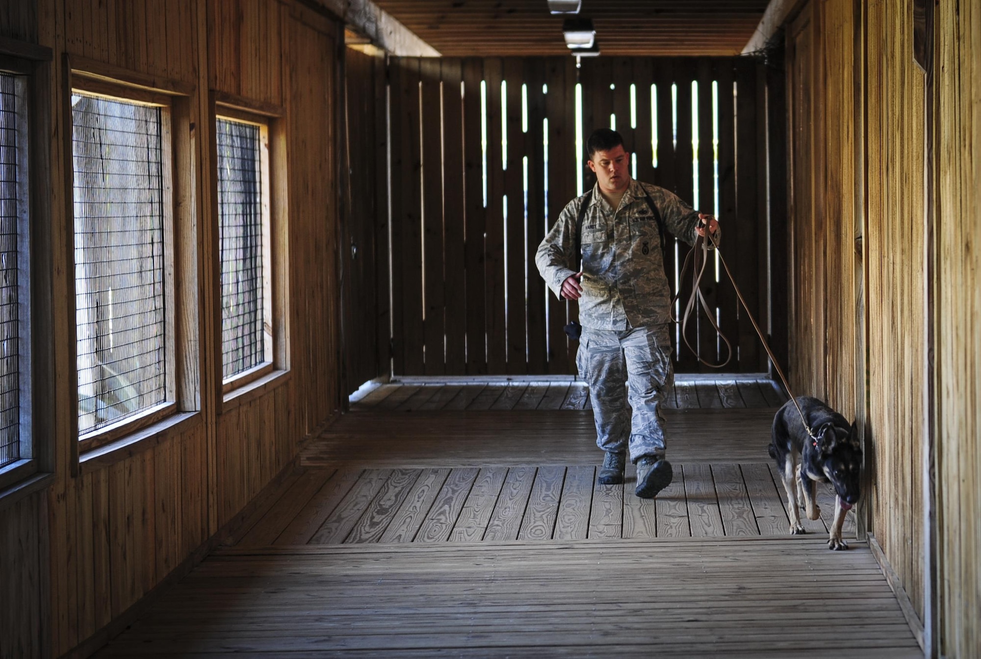 Staff Sgt. Brandon Hardy, a military working dog handler with the 96th Test Wing Security Forces Squadron, walks with his military working dog Ajda, at the Gulfarium Marine Adventure Park, Dec. 5, 2015. The showdown was hosted Dec. 5-6 by the 1st Special Operations Security Forces Squadron K-9 unit as a friendly competition, and was a learning experience for both handler and K-9, to practice detecting narcotic and explosive odors. (U.S. Air Force photo by Senior Airman Meagan Schutter)