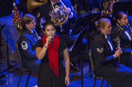 Airman 1st Class Alycia Cancel, United States Air Force Band of the West vocalist, performs during the Holiday in Blue concert Dec. 7, 2015 at the Edgewood Independent School District Theatre for the Performing Arts in San Antonio, Texas. The concert included a variety of holiday songs from around the world, a children’s story and a sing-a-long. Attendees included members of JBSA, community members and retirees. The Airmen assigned to the band are highly-trained professional musicians who have dedicated themselves to serving their country through music. (U.S. Air Force photo by Johnny Saldivar)