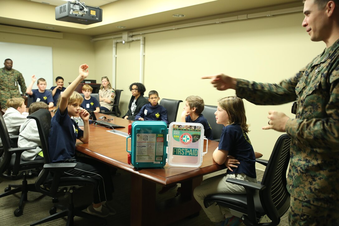 Hospital Corpsman 2nd Class Aaron Bevan, a hospital corpsman with 4th Marine Aircraft Wing, leads Webelos Cub Scout Pack 48 in first-aid training at Marine Corps Support Facility New Orleans on Dec. 5, 2015. The training, led by Bevan and Staff Sgt. Charlee Law, an administrative chief with 4th MAW, included identifying different types of ailments and injuries that required first aid, as well as an analysis of the contents in a common first-aid kit and their correct usage. The scouts attended the training as a requirement for earning their First Responder achievement badge. 