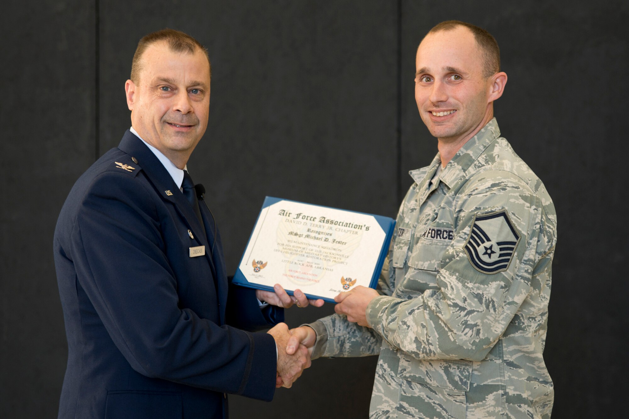U.S. Air Force Col. Craig Drescher, commander, 913th Airlift Group, and Master Sgt. Michael Jester, fabrication flight chief, 913th Maintenance Squadron, pose for a photo during Commander’s Call at Little Rock Air Force Base, Ark., Dec. 6, 2015. Jester was one of ten individuals from the 913th AG who helped restore a Vietnam era chopper for the Jacksonville Museum of Military History and received a certificate from the Air Force Association’s David D. Terry Jr. Chapter, recognizing their accomplishment. (U.S. Air Force photo by Master Sgt. Jeff Walston/Released) 