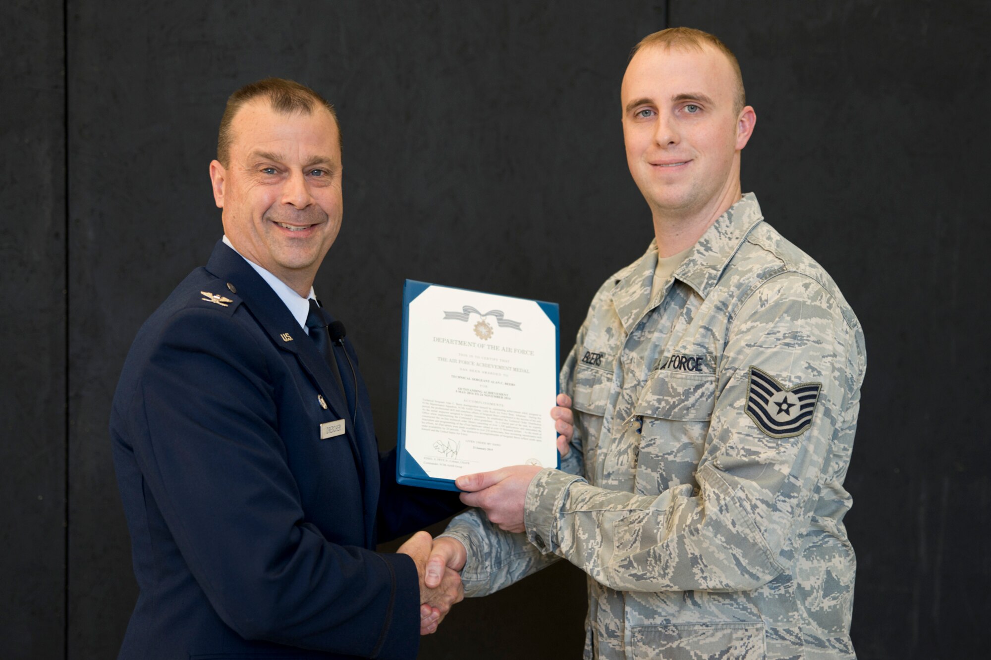 U.S. Air Force Col. Craig Drescher, commander, 913th Airlift Group, and Tech. Sgt. Alan C. Beers, quality insurance inspector, 913th Maintenance Squadron, pose for a photo during Commander’s Call at Little Rock Air Force Base, Ark., Dec. 6, 2015. Beers was awarded the Air Force Achievement Medal for outstanding achievement in his field from 5 May 2014 to 24 November 2014. Colonel Drescher also recognized 24 additional Airmen for personal achievements. (U.S. Air Force photo by Master Sgt. Jeff Walston/Released) 