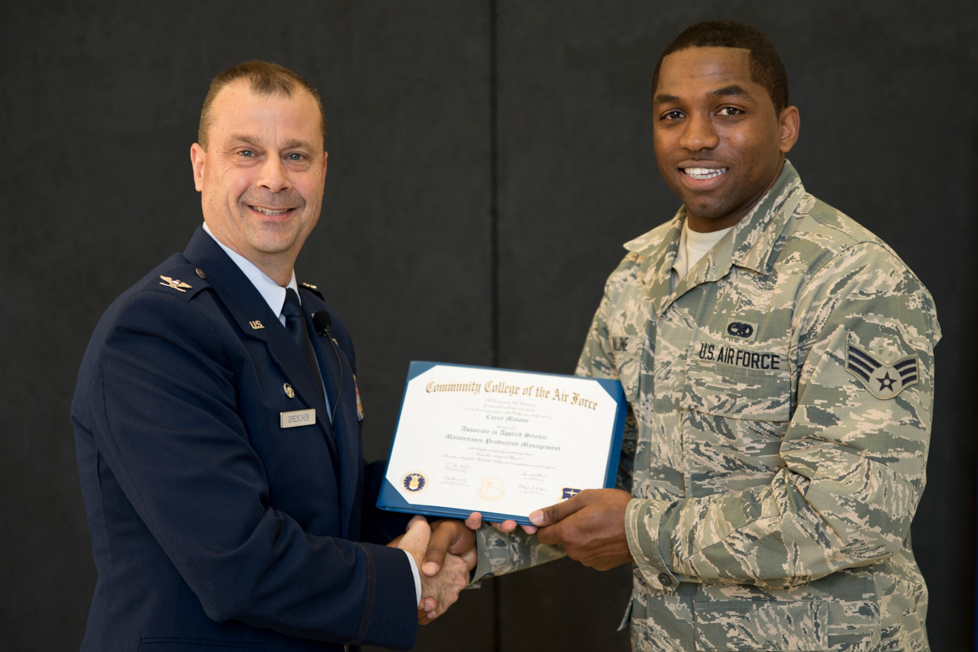 U.S. Air Force Col. Craig Drescher, commander, 913th Airlift Group, and Senior Airman Corey Malone, 913th Maintenance Squadron, maintenance management production technician, pose for a photo during Commander’s Call at Little Rock Air Force Base, Ark., Dec. 6, 2015. Malone received his Community College of the Air Force Associates Degree in Maintenance Production Management. Colonel Drescher also recognized 24 additional Airmen for personal achievements. (U.S. Air Force photo by Master Sgt. Jeff Walston/Released) 