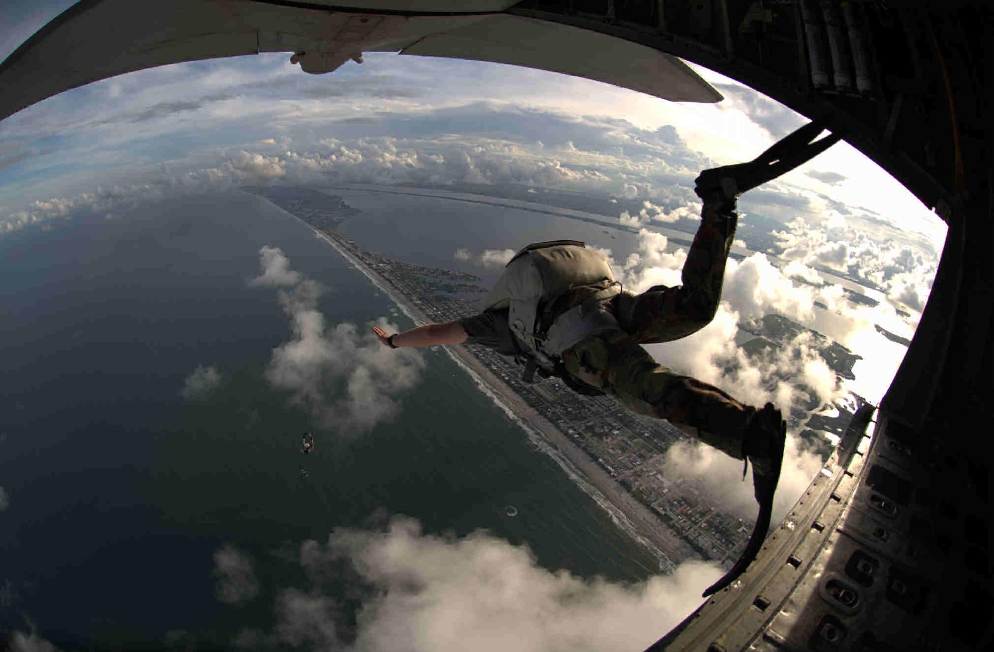 An Air Force Reserve Pararescueman from the 920th Rescue Wing parachutes out of a HC-130P/N to a landing zone established in the Atlantic Ocean off Cocoa Beach, Florida.