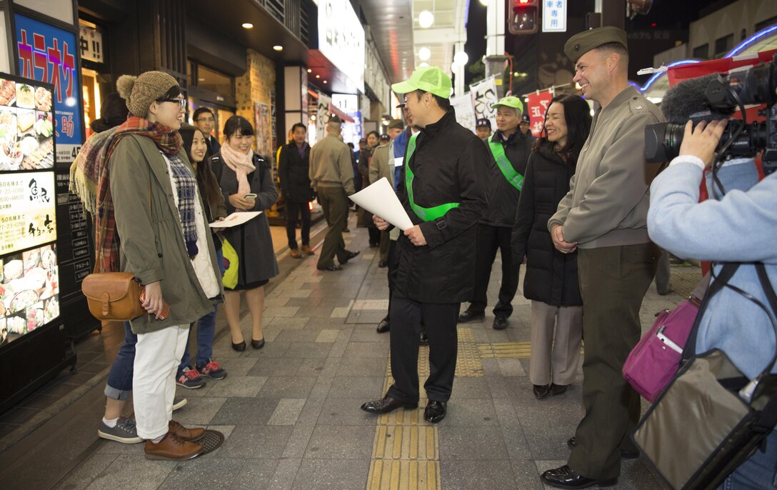 Lt. Col. Gary Thomason, executive officer of Marine Corps Air Station Iwakuni, Japan, and Iwakuni City officials engage with local Japanese citizens during the 6th Joint Leadership Walk in Iwakuni Dec. 4, 2015. Yoshihiko Fukuda, mayor of Iwakuni City, led participants through the city to foster the unique and long lasting relationship between the air station and Iwakuni City.