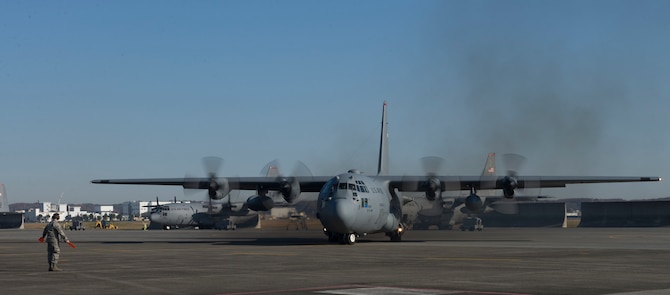 A C-130 Hercules is marshaled onto the flightline before taking off to participate in Operation Christmas Drop 2015 at Yokota Air Base, Japan, Dec. 7, 2015. Over the course of six days, critical supplies will be dropped to 56 Micronesian islands, impacting approximately 20,000 people as part of the longest-running Department of Defense humanitarian aid disaster relief mission. (U.S. Air Force photo by Senior Airman David C. Danford/Released)