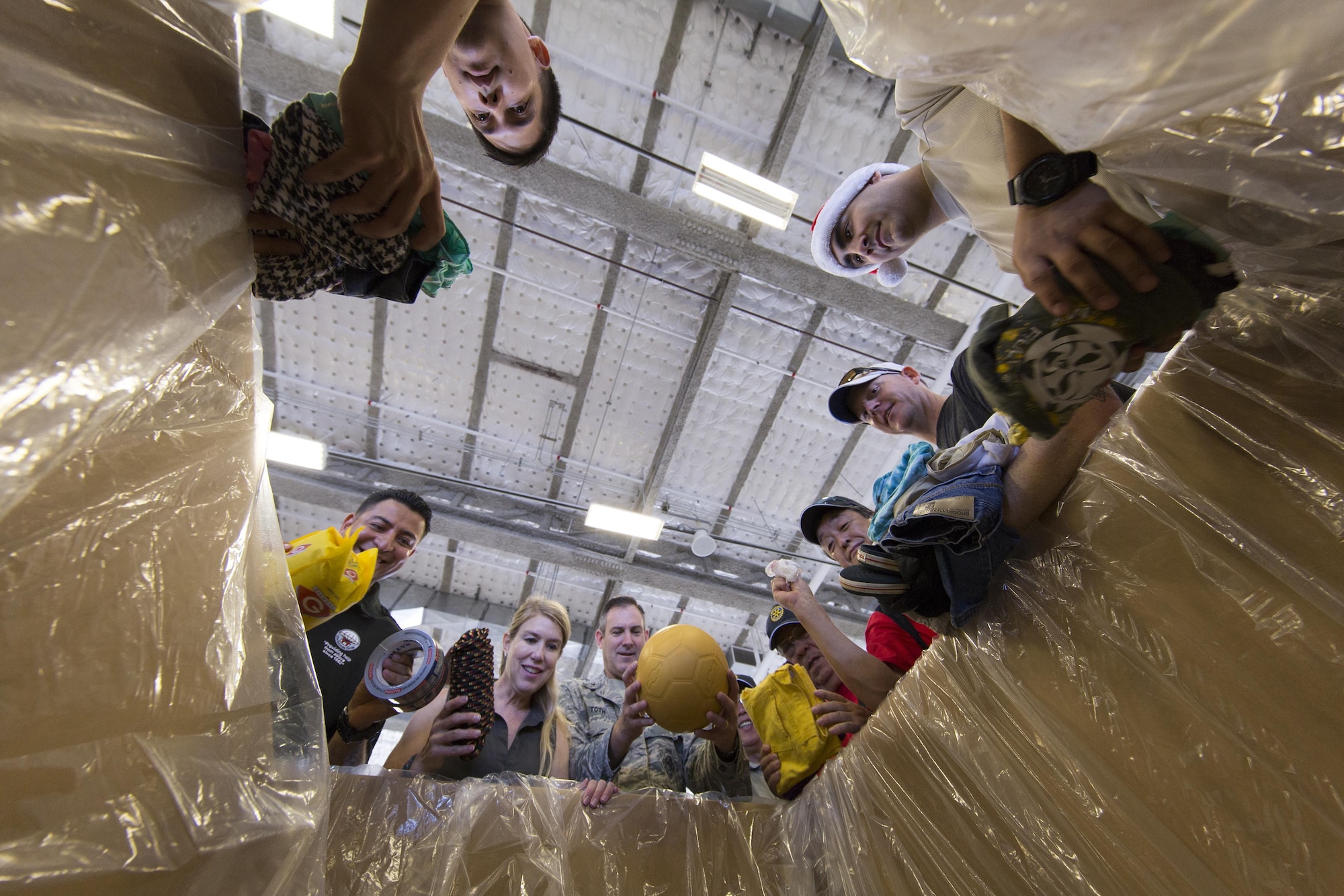 (Center) Brig. Gen. Andrew Toth, 36th Wing Group commander, and volunteers throughout the local community place relief items into a box while sorting donations for Operation Christmas Drop at Andersen Air Force Base, Guam, Dec. 5, 2015. More than 40,000 pounds of goods will be dropped to 56 islands throughout the Commonwealth of the Northern Marianas, Federated States of Micronesia and Republic of Palau during Operation Christmas Drop 2015, the longest running Department of Defense humanitarian airdrop mission. (U.S. Air Force photo by Osakabe Yasuo/Released)