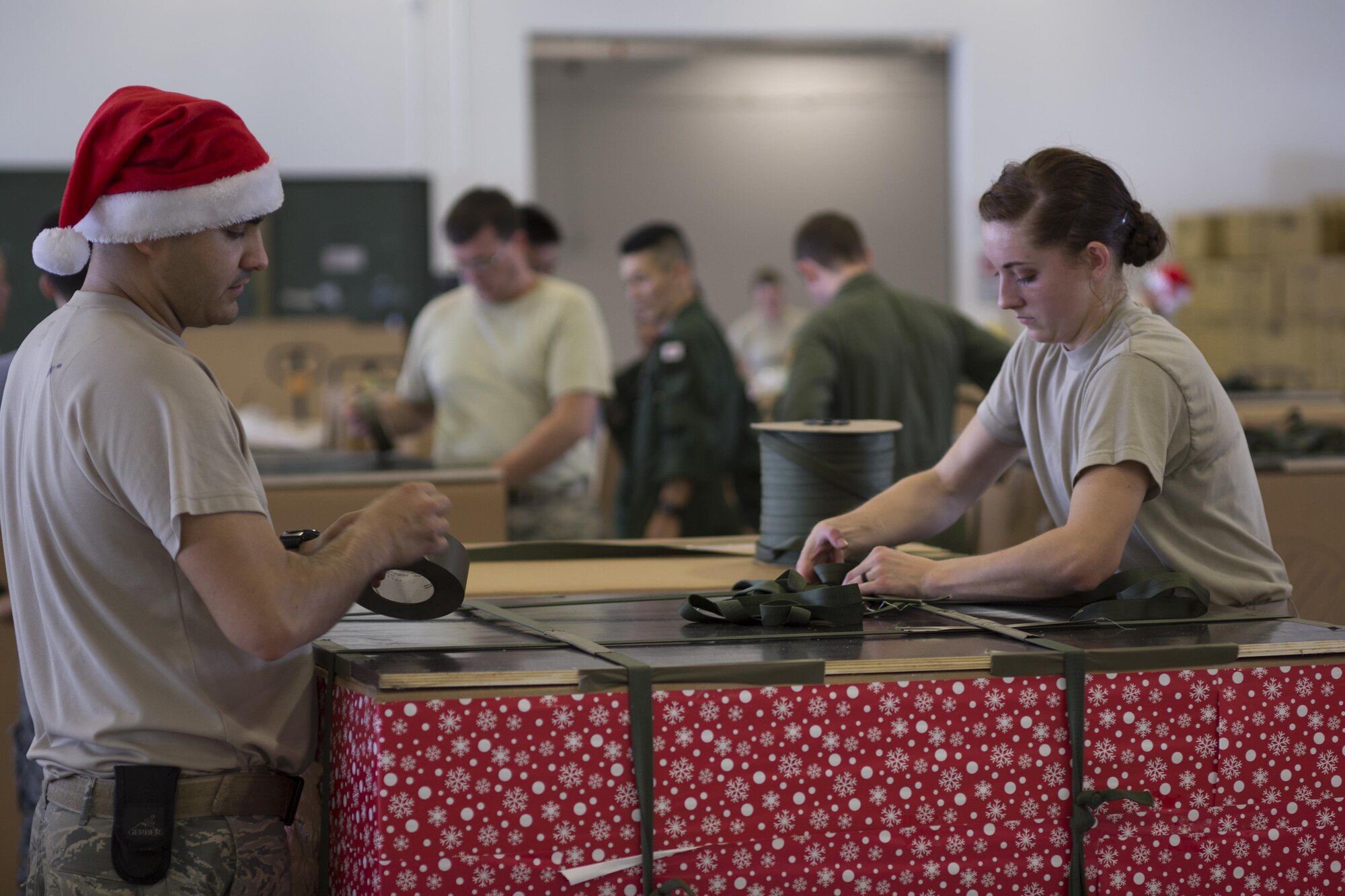 (Left to right) Staff Sgt. Joshua McDonald and Airman 1st Class Cassandra Cobb, 374th Logistics Readiness Squadron combat mobility flight, build a low-cost, low-altitude bundle destined for the island of Fais,  during Operation Christmas Drop at Andersen Air Force Base, Guam, Dec. 5, 2015. More than 40,000 pounds of donated goods, including relief supplies will be sent to 56 Micronesian islands during the operation, the longest running Department of Defense humanitarian airdrop mission. (U.S. Air Force photo by Osakabe Yasuo/Released)