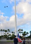 Members of the Hickam Honor Guard perform flag detail as two F-22 Raptors fly over during the 74th attack on Hickam Field Remembrance Ceremony hosted by the 15th Wing on Joint Base Pearl Harbor-Hickam, Hawaii, Dec. 7, 2015. Survivors and their family members attended the ceremony, which honors the men and women who lost their lives on Hickam Field during the two waves of attacks launched by the Imperial Japanese Navy on Dec. 7, 1941. (U.S. Air Force photo by Tech. Sgt. Aaron Oelrich/Released) 