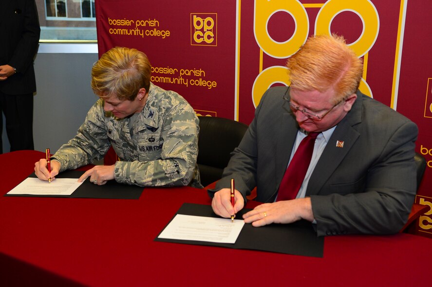 Col. Kristin Goodwin, 2nd Bomb Wing commander, and Rick Bateman Jr., Bossier Parish Community College chancellor, sign a proclamation giving Airmen and their families a chance to attend sports and performing arts events free of charge at BPCC, Dec. 4, 2015. During the signing, Goodwin spoke to BPCC students about the 2nd Bomb Wing's priorities of people, mission and pride, and how they align with BPCC's goal of empowering students and Airmen.