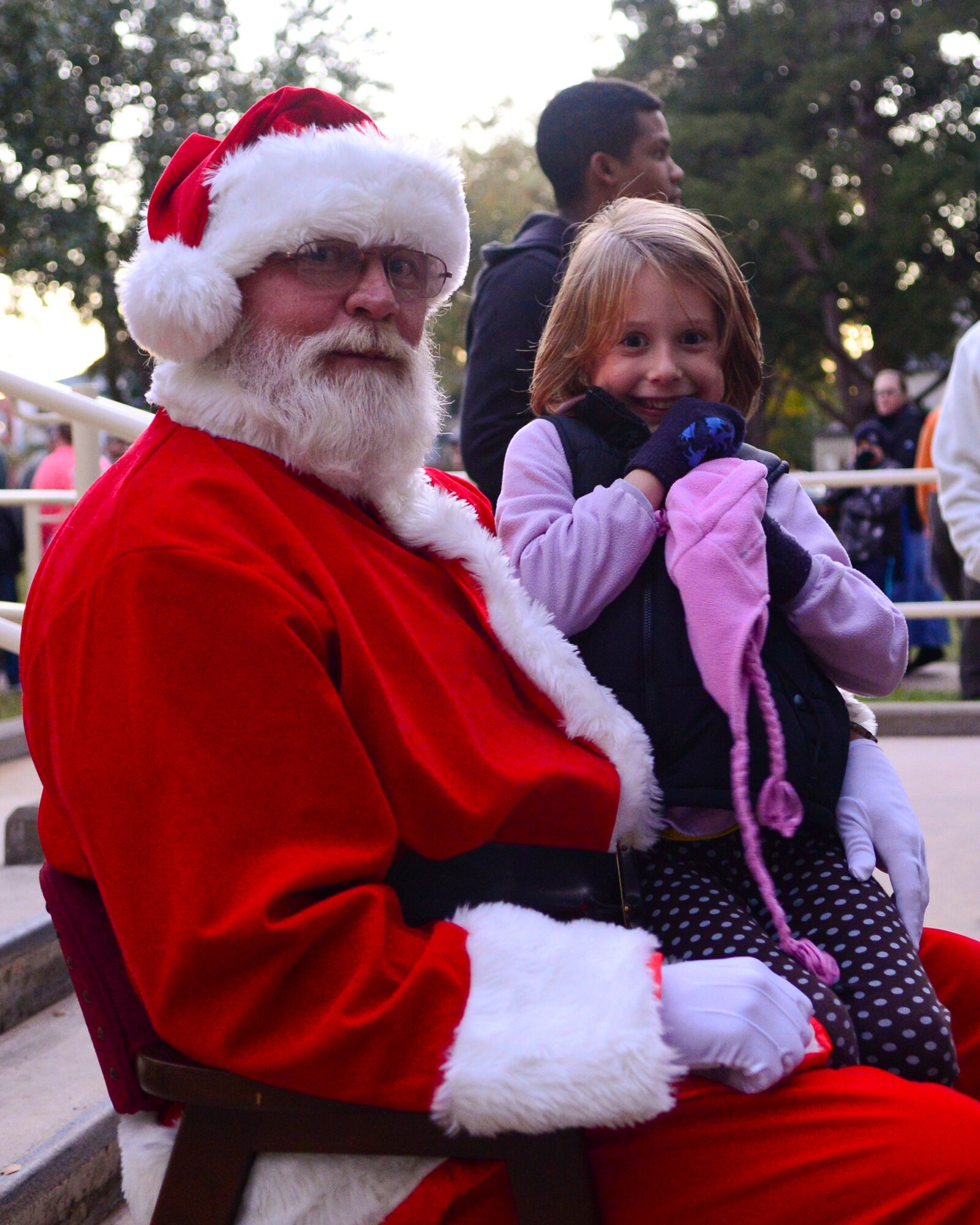 A child sits on Santa's lap outside Chapel One at Barksdale Air Force Base, La., Dec. 3, 2015. Children from across the base lined up to tell Santa what they wanted for Christmas at the base's annual tree-lighting ceremony. (U.S. Air Force photo/Senior Airman Benjamin Raughton)