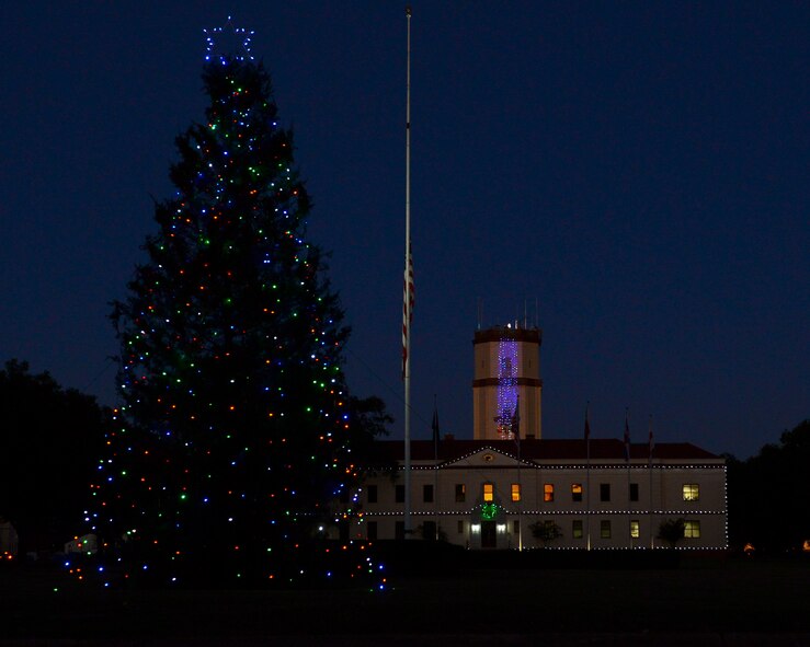 The 2nd Bomb Wing Christmas tree and headquarters are lit during a ceremony at Barksdale Air Force Base, La., Dec. 3, 2015. For more than two days, 2nd Civil Engineer Squadron Airmen erected the tree and decorated it with lights. (U.S. Air Force photo/Senior Airman Benjamin Raughton)