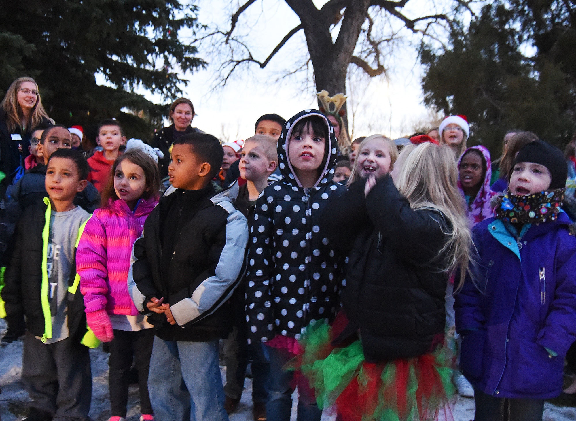 Children from the F.E. Warren Air Force Base, Wyo., Youth Center sing Christmas songs at the beginning of the base's tree lighting ceremony, Dec. 4, 2015. After the switch was flipped, the festivities moved into the Fall Hall Community Center where children were able to visit with Santa and Mrs. Claus, decorate cookies and do other crafts, and their parents strolled stalls selling a wide assortment of craft items. (U.S. Air Force photo by R.J. Oriez)