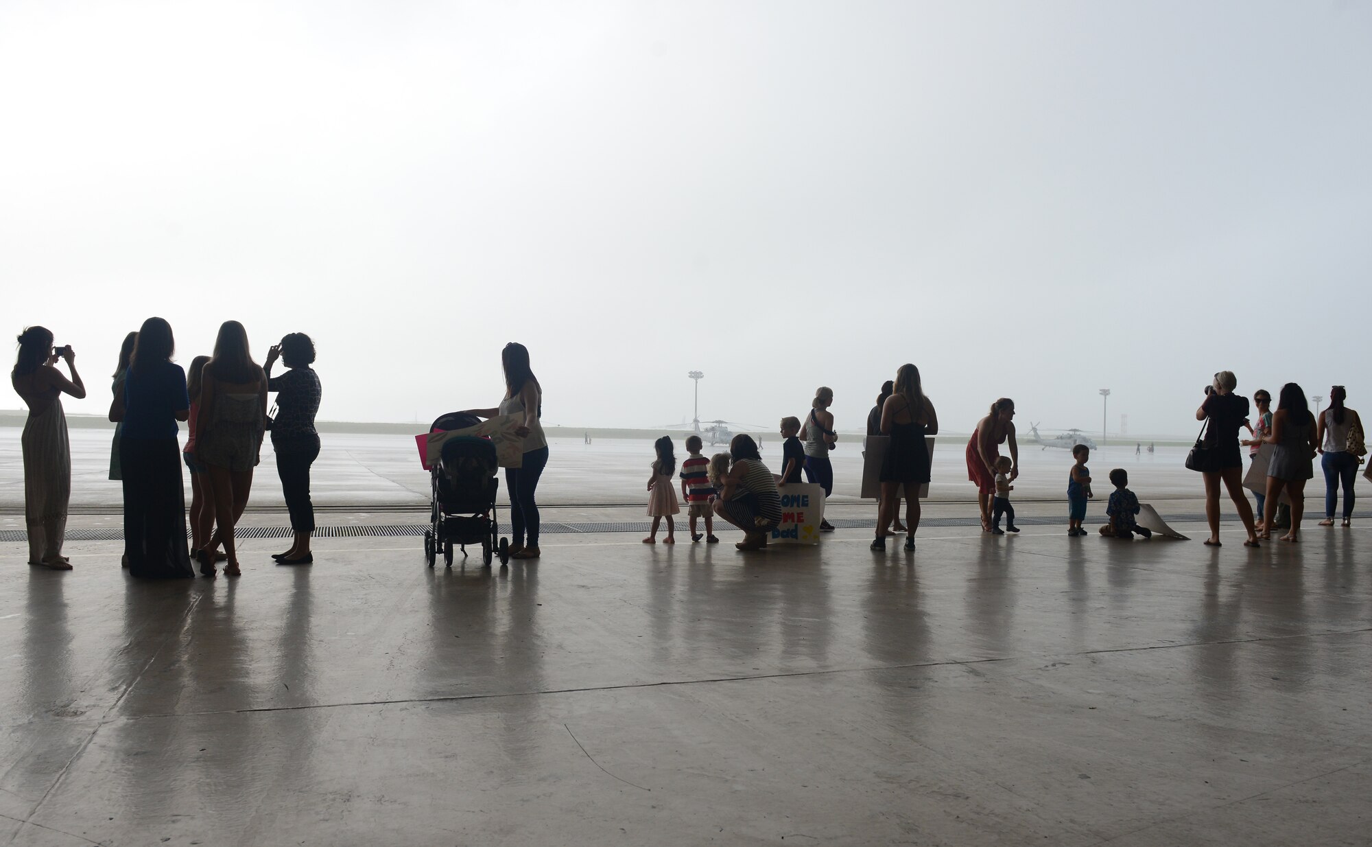 Spouses and children wait for Sailors from Detachment 1 Dec. 8, 2015, at Andersen Air Force Base, Guam. Detachment 1 returned after a seven month deployment in the Pacific theater. (U.S. Air Force photo by Airman 1st Class Arielle Vasquez/Released)